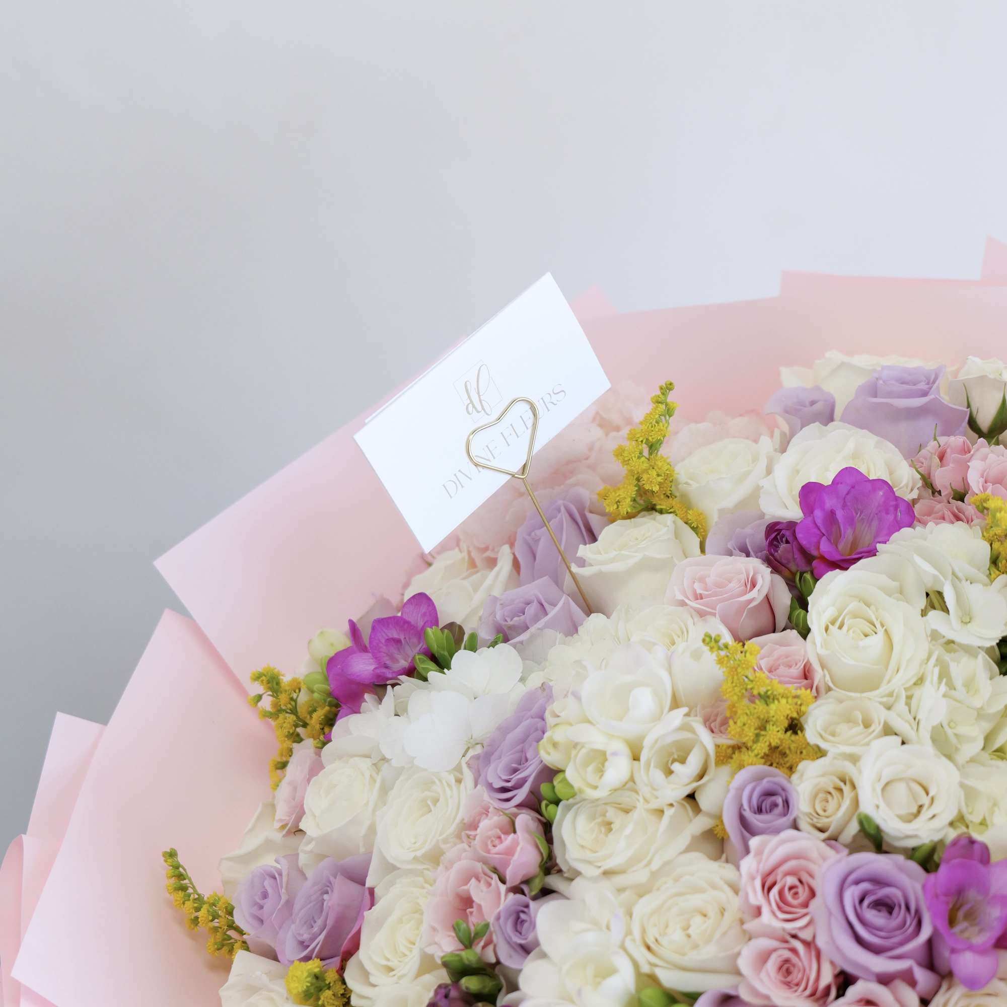 A cute and charming bouquet filled with soft, pastel blooms in creamy