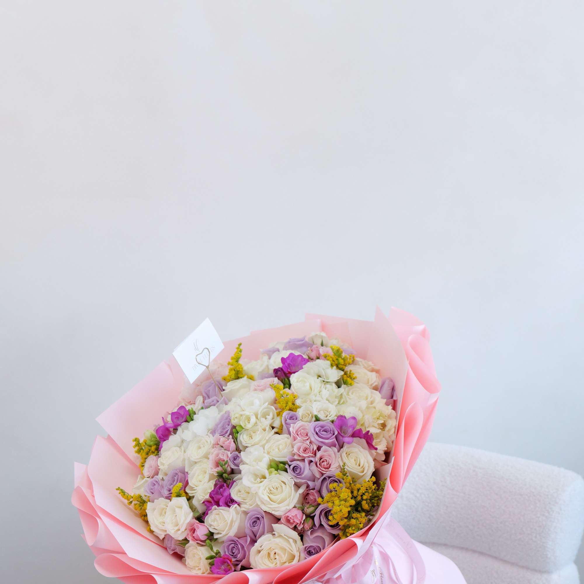 A cute and charming bouquet filled with soft, pastel blooms in creamy