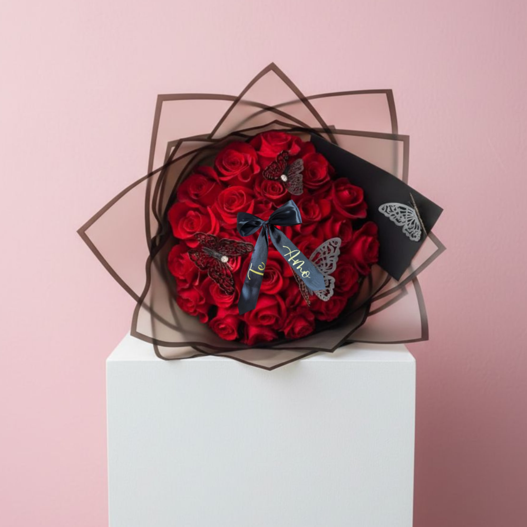 Bouquet of red roses wrapped in dark paper with butterfly accents