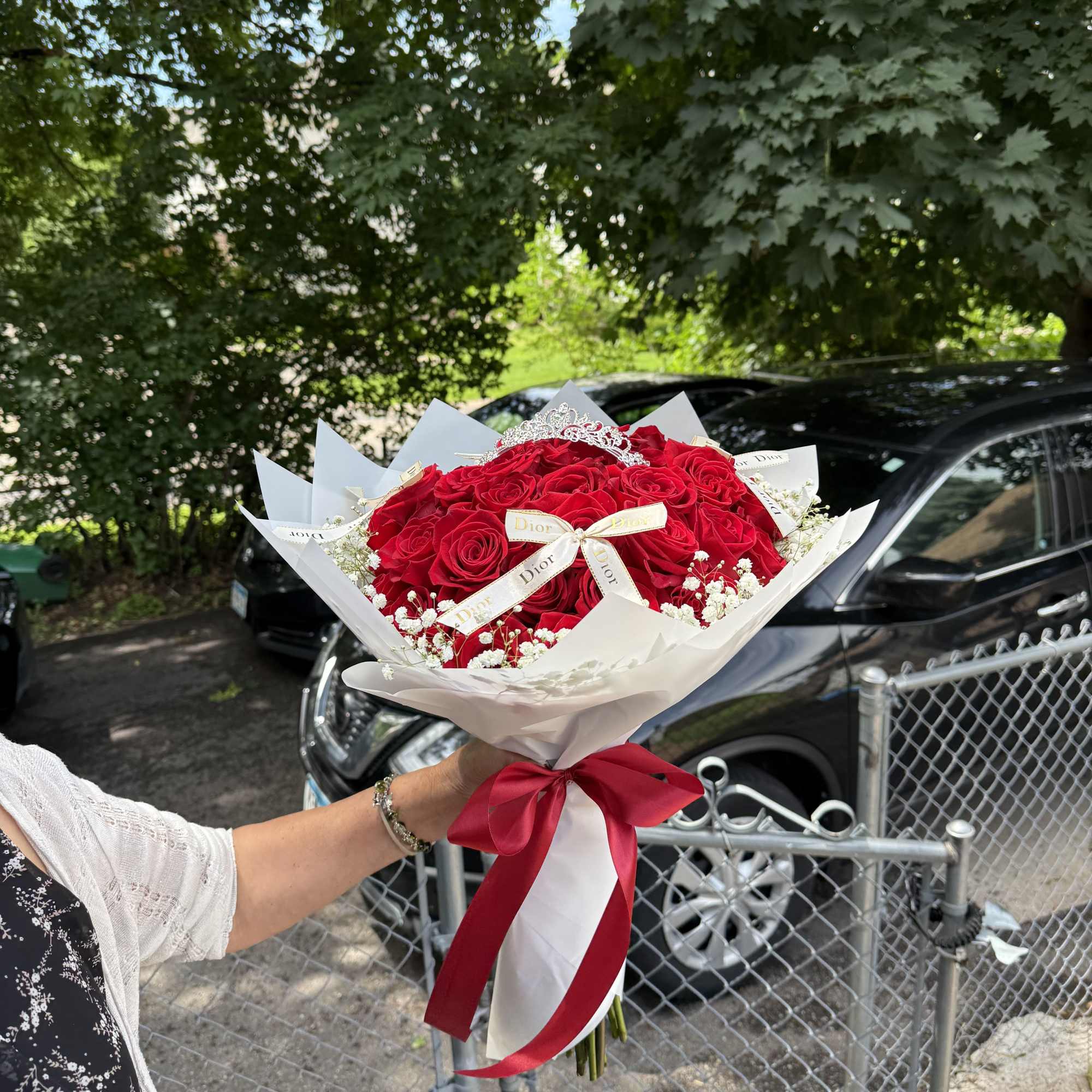 Bouquet of red roses wrapped in white paper with a red ribbon