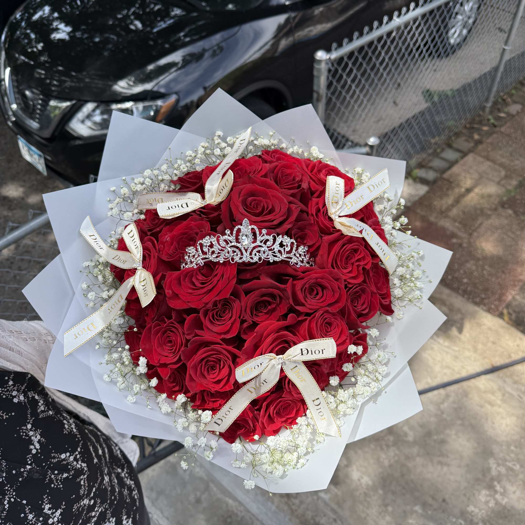 Bouquet of red roses with white baby's breath and a tiara topper