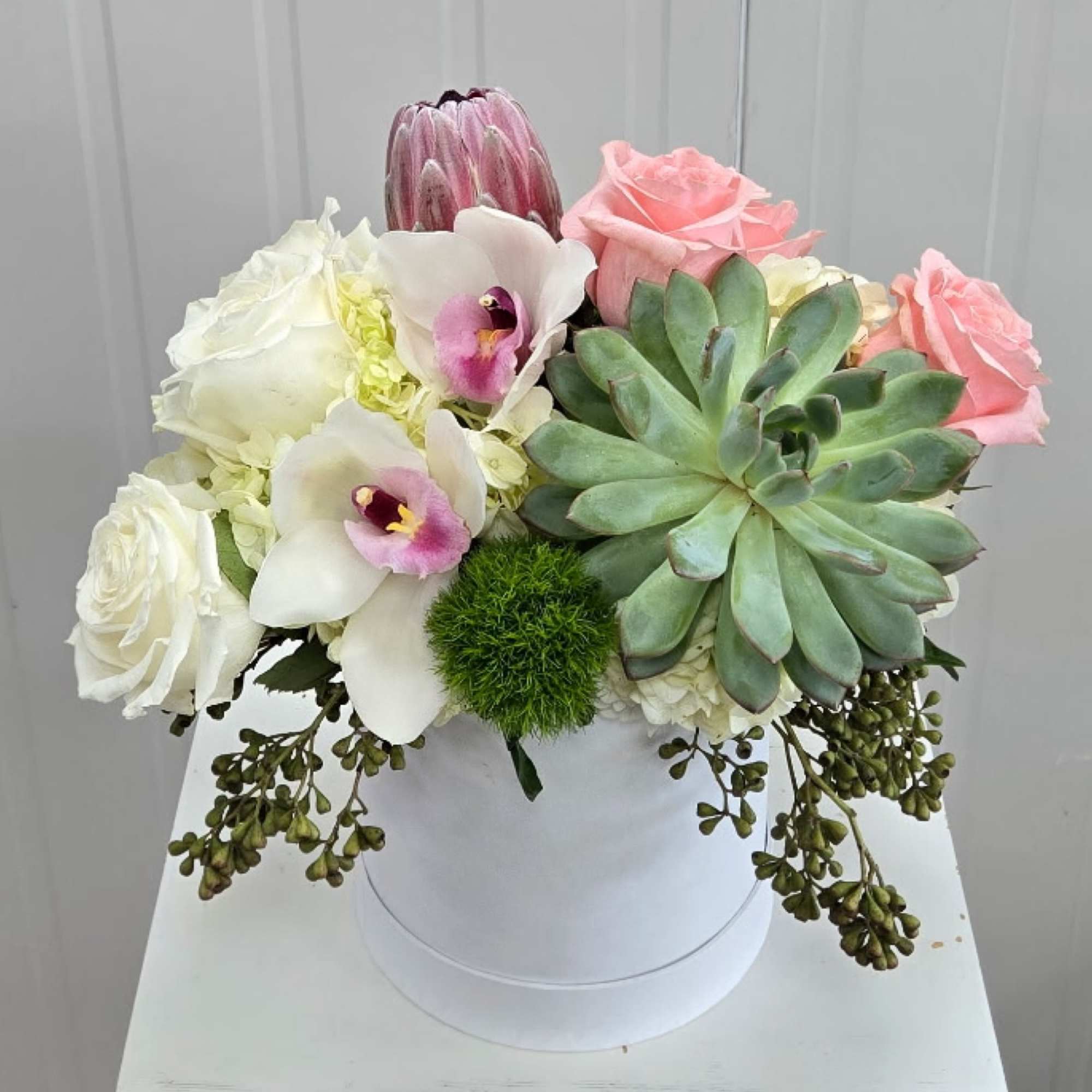 A Low and Lush Arrangement with Premium Flowers in White Hat Box.