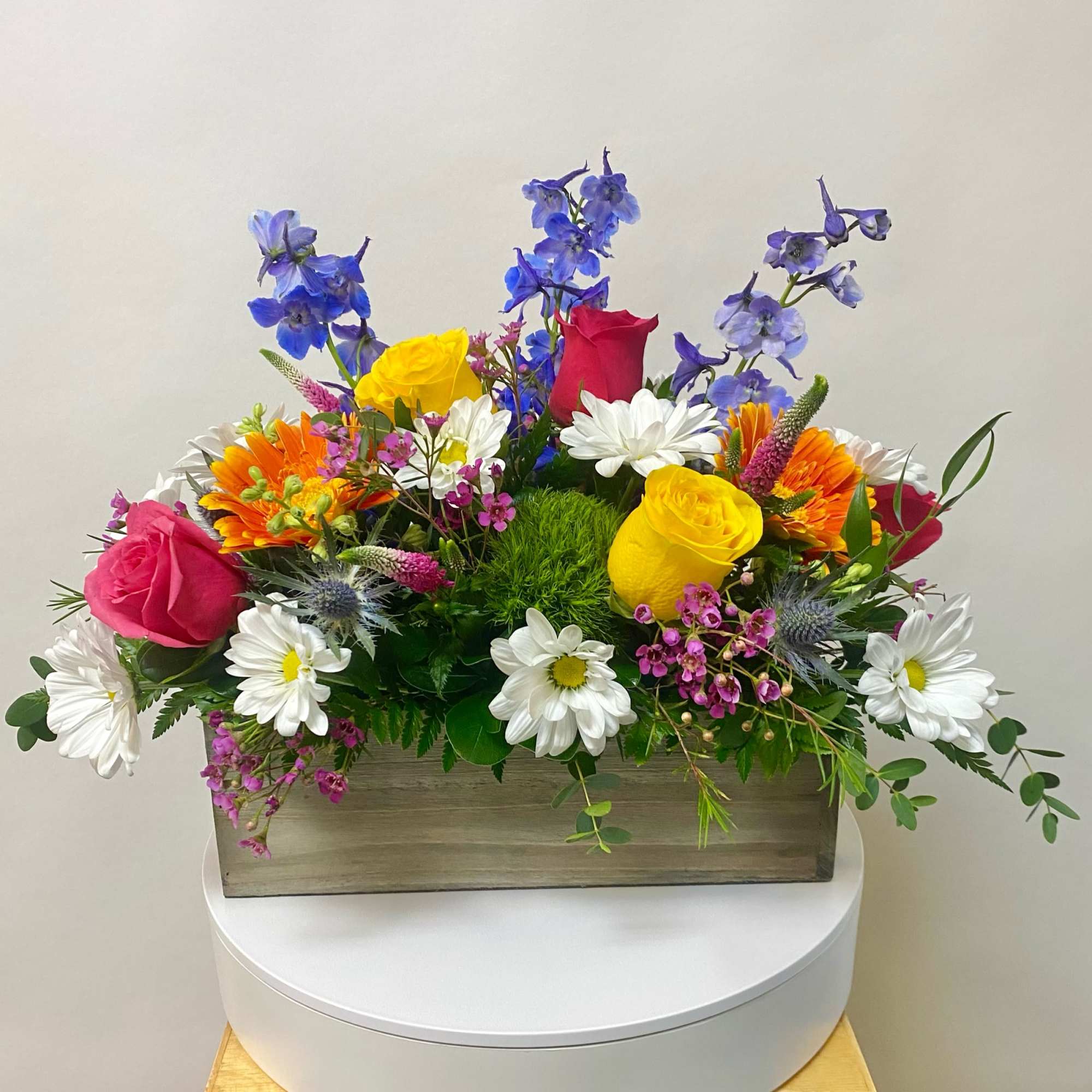 Colorful mixed flower arrangement in a rectangular wooden box