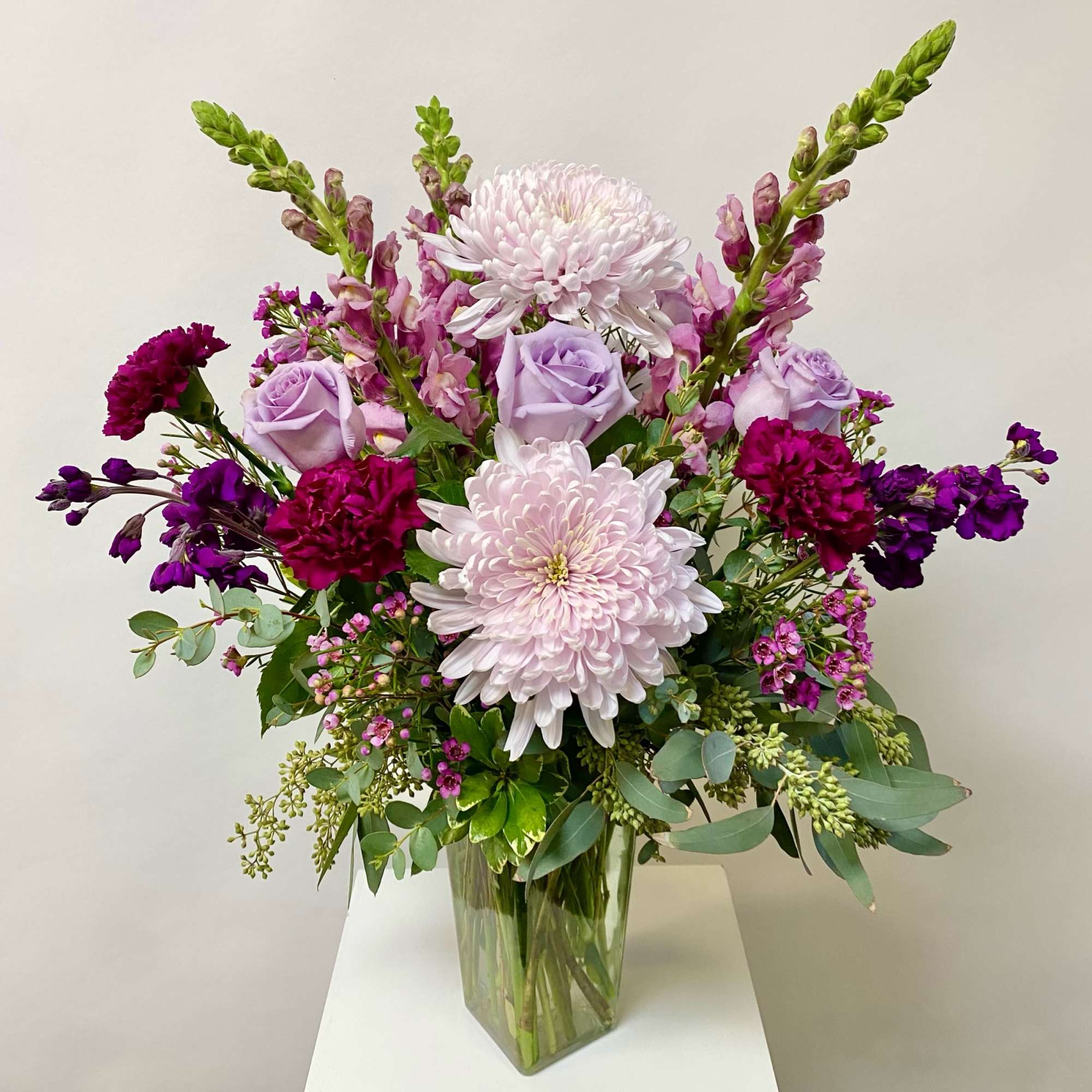 Lavender roses and pink chrysanthemums in a clear glass vase