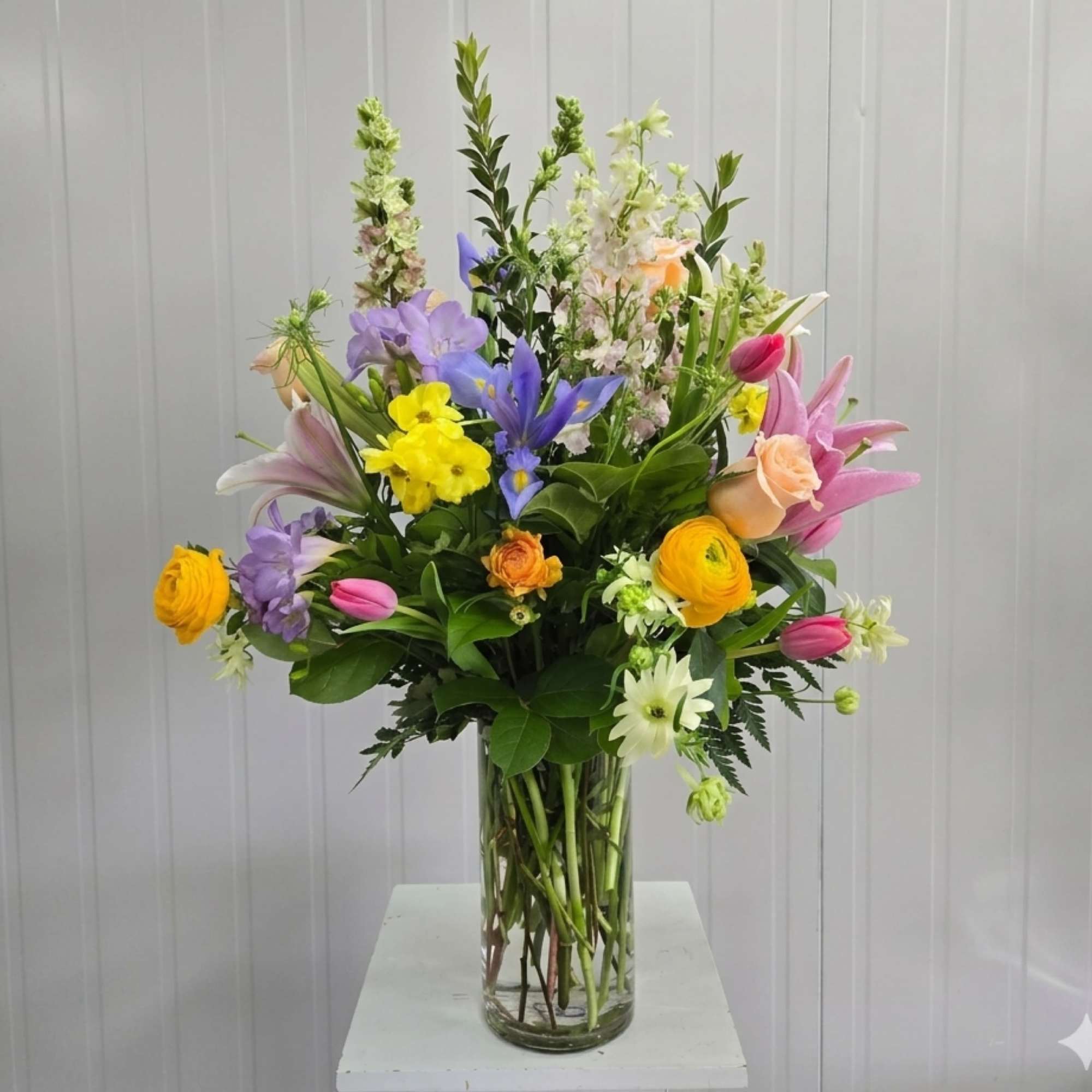 A Designers Choice Assortment of Fresh Cut Flowers Arranged in a Tall