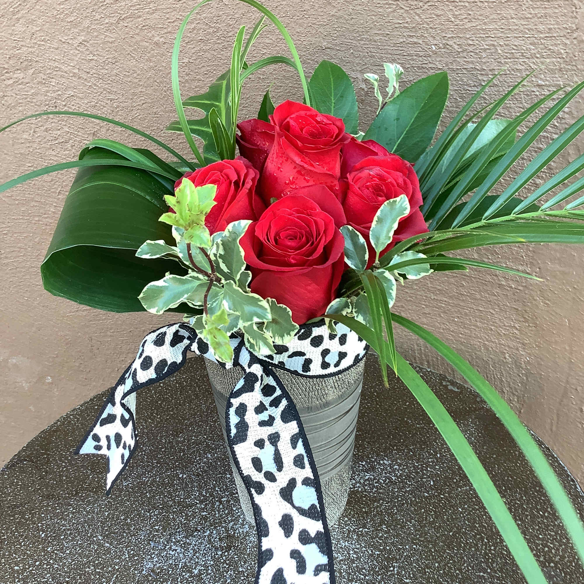 Six beautiful red roses with tropical forges and a black cheetah ribbon