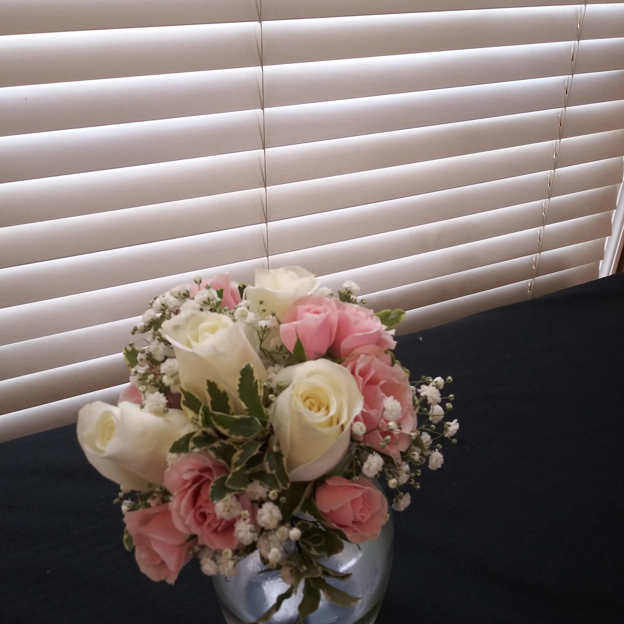 Pink and white rose bouquet in a clear glass vase