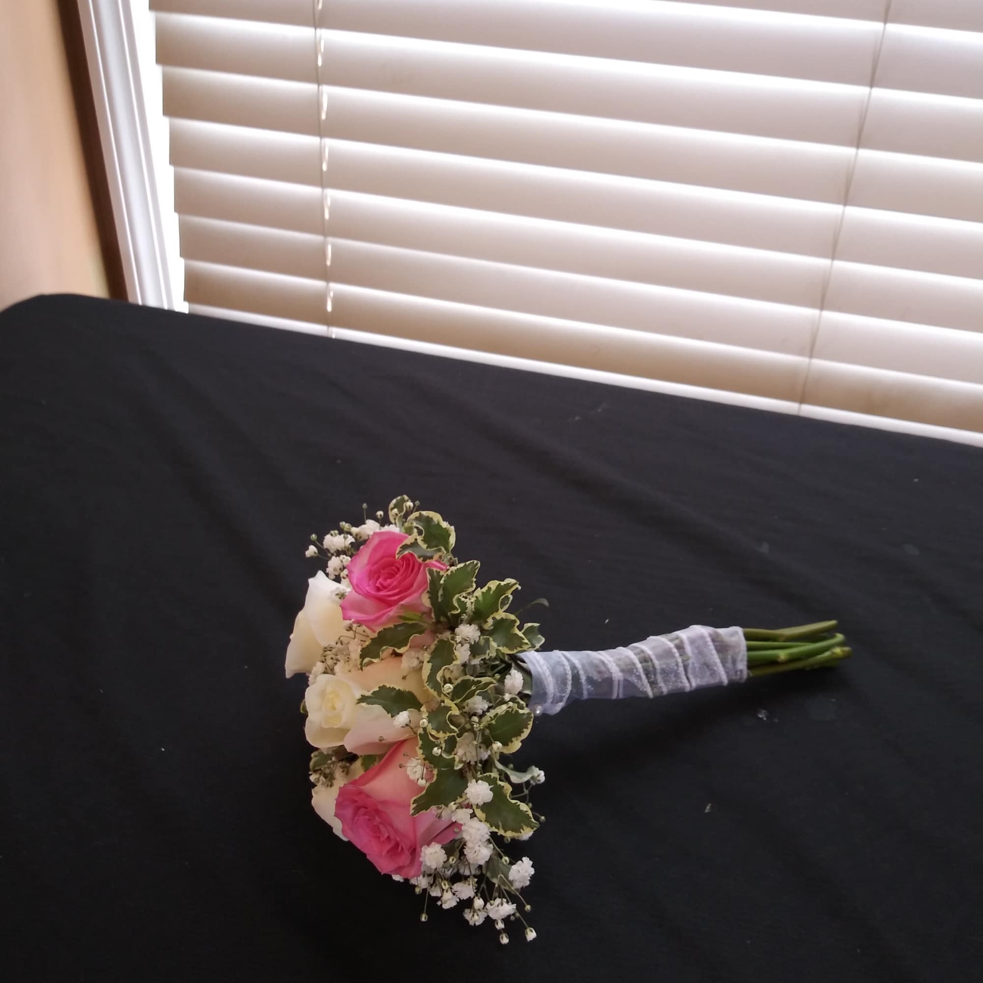 Small bouquet of pink and white roses with baby's breath