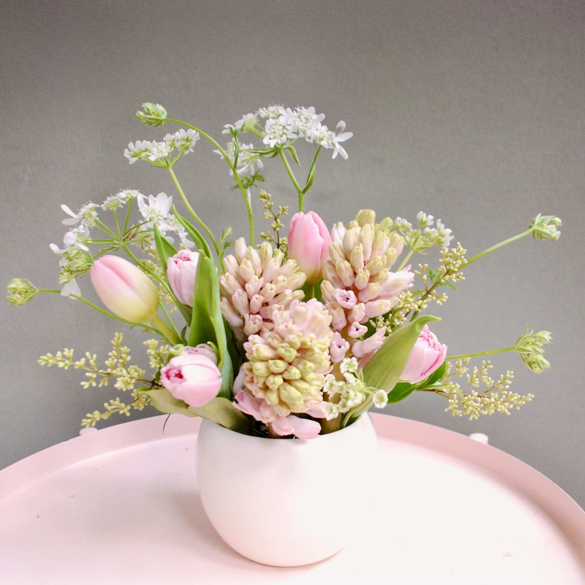 Soft pink tulips and clusters of pale pink and cream hyacinth-like blooms
