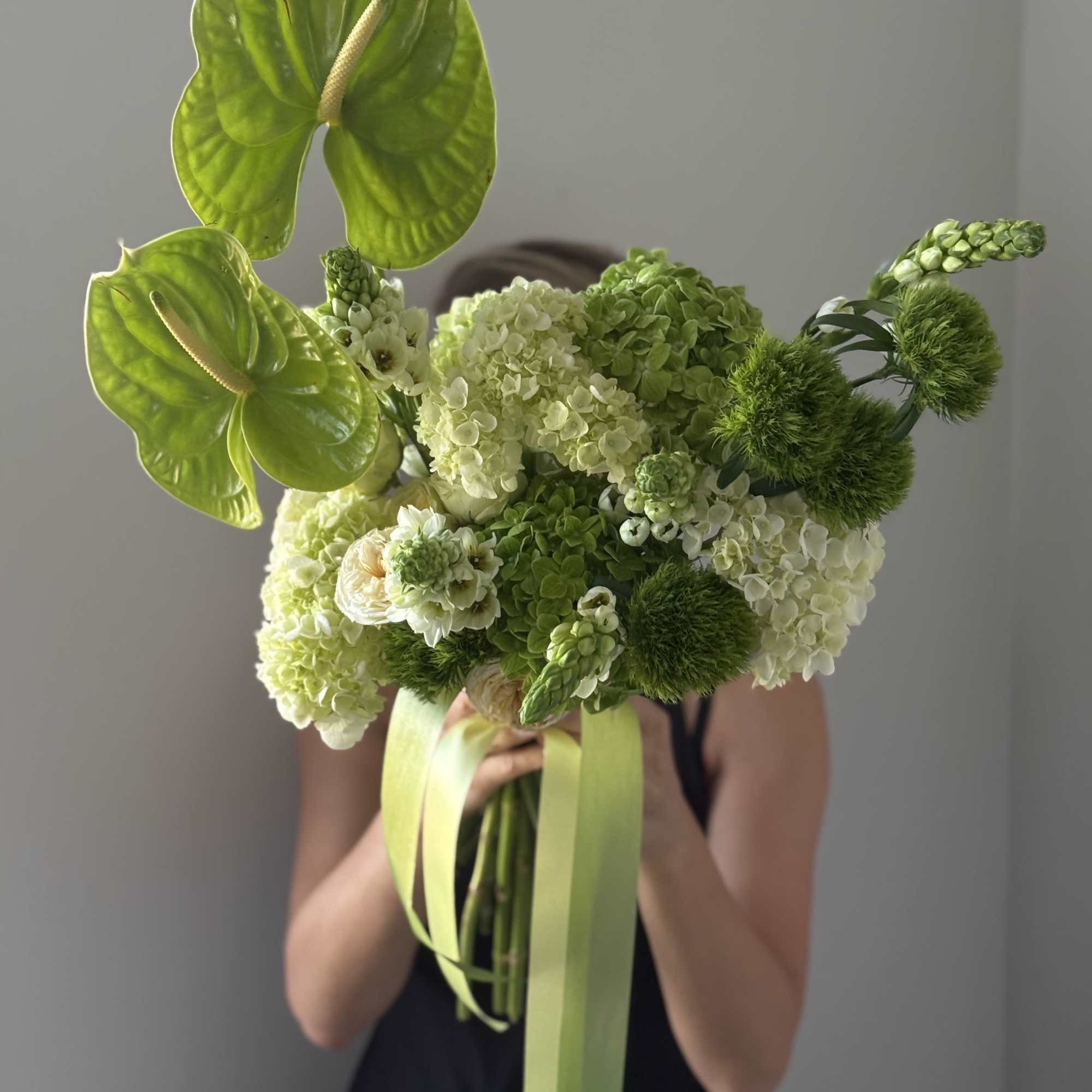 Bouquet of green anthuriums and hydrangeas with ribbon