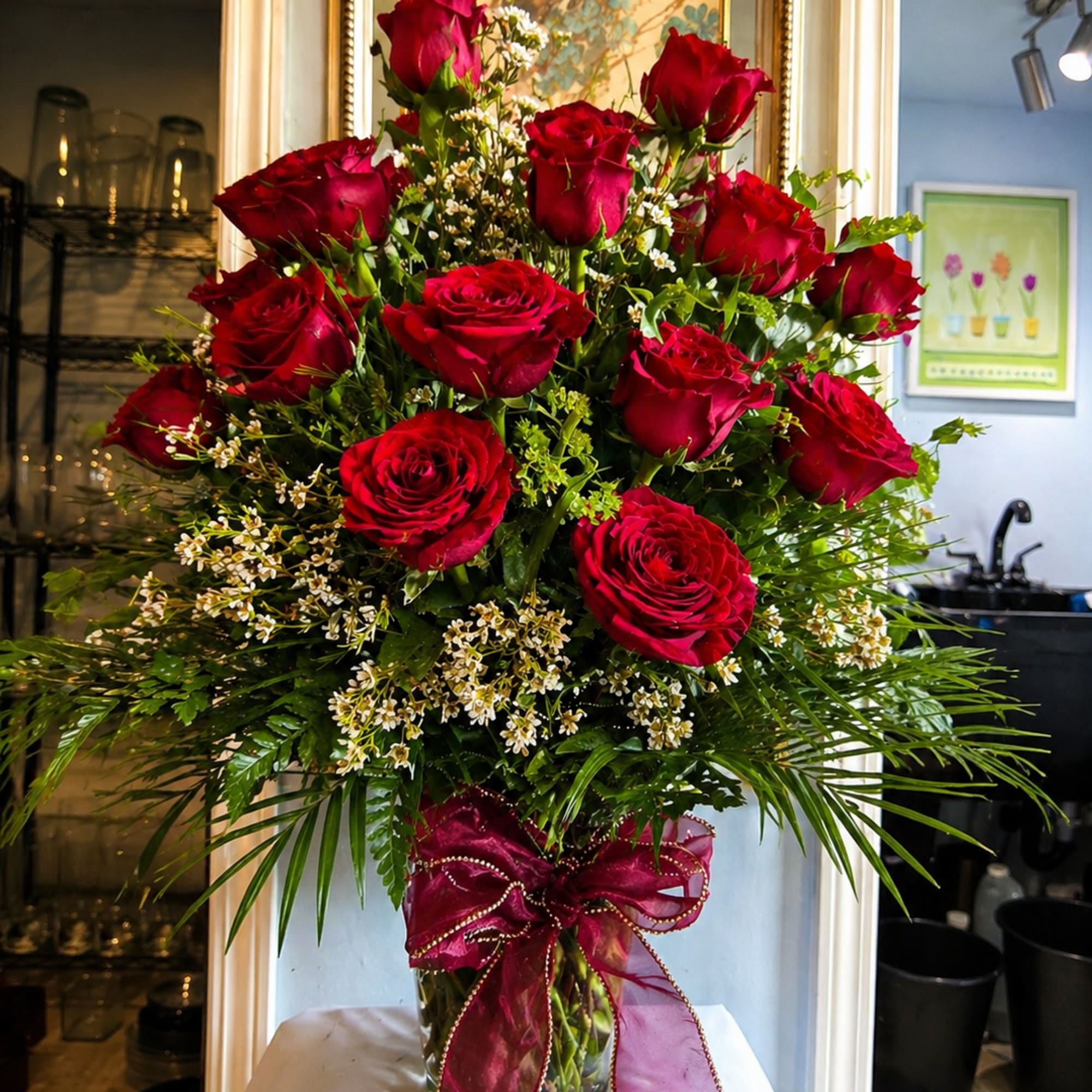 A clustered tower of deep red roses rises above a cloud of
