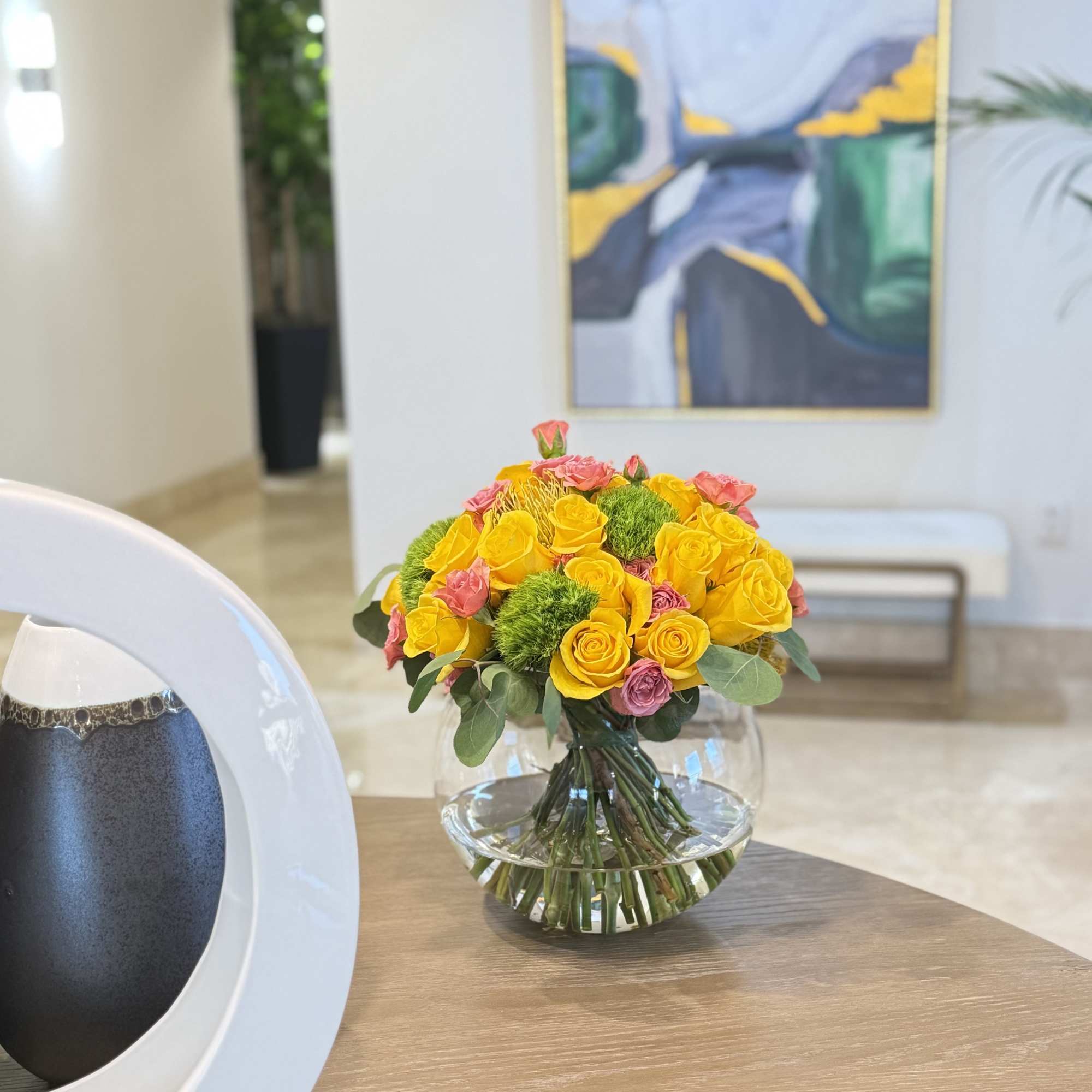 Yellow and pink rose bouquet in a clear glass vase