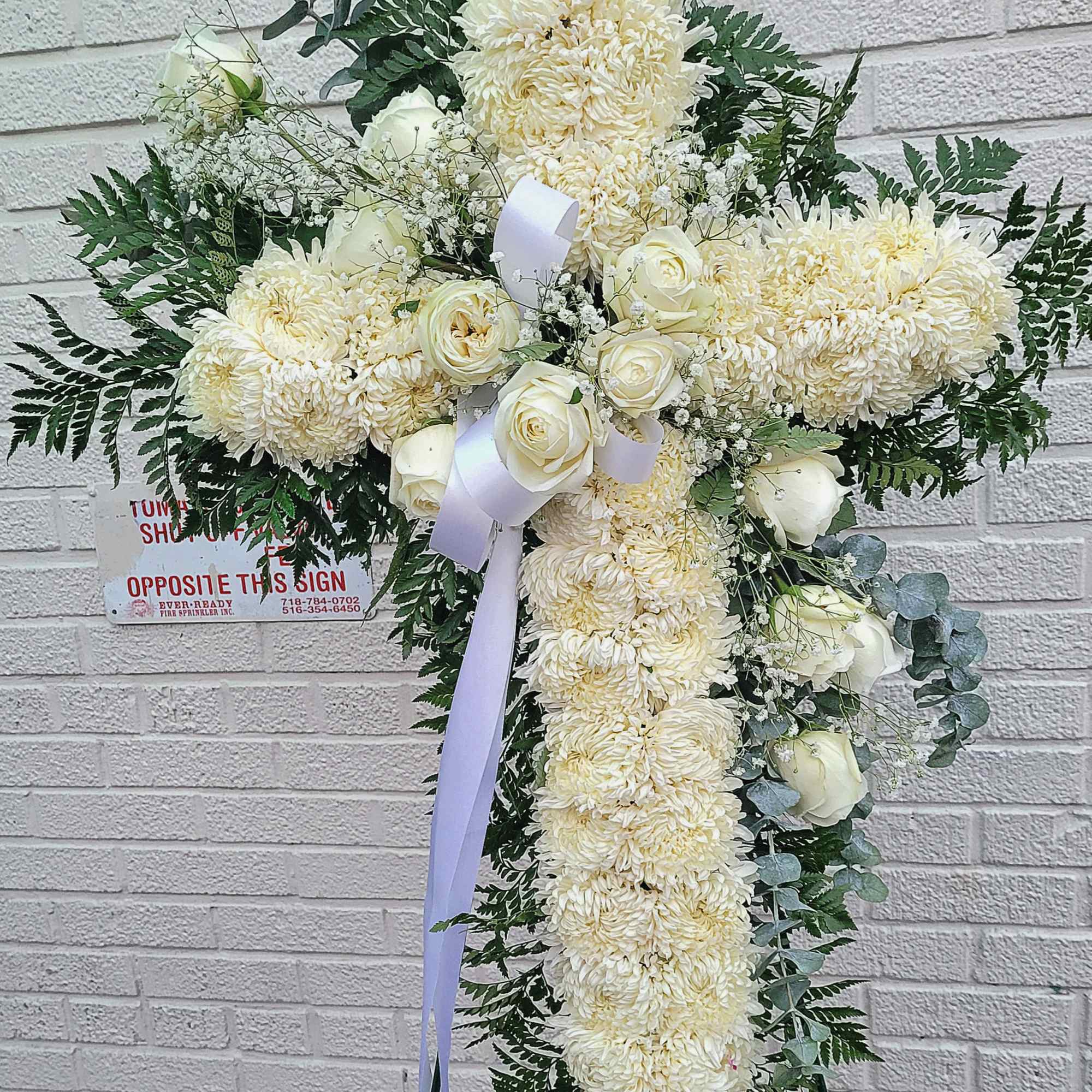 it is made with:
30 white mums
12 white roses
2 baby breath
greens 
eucalyptus
white bow
