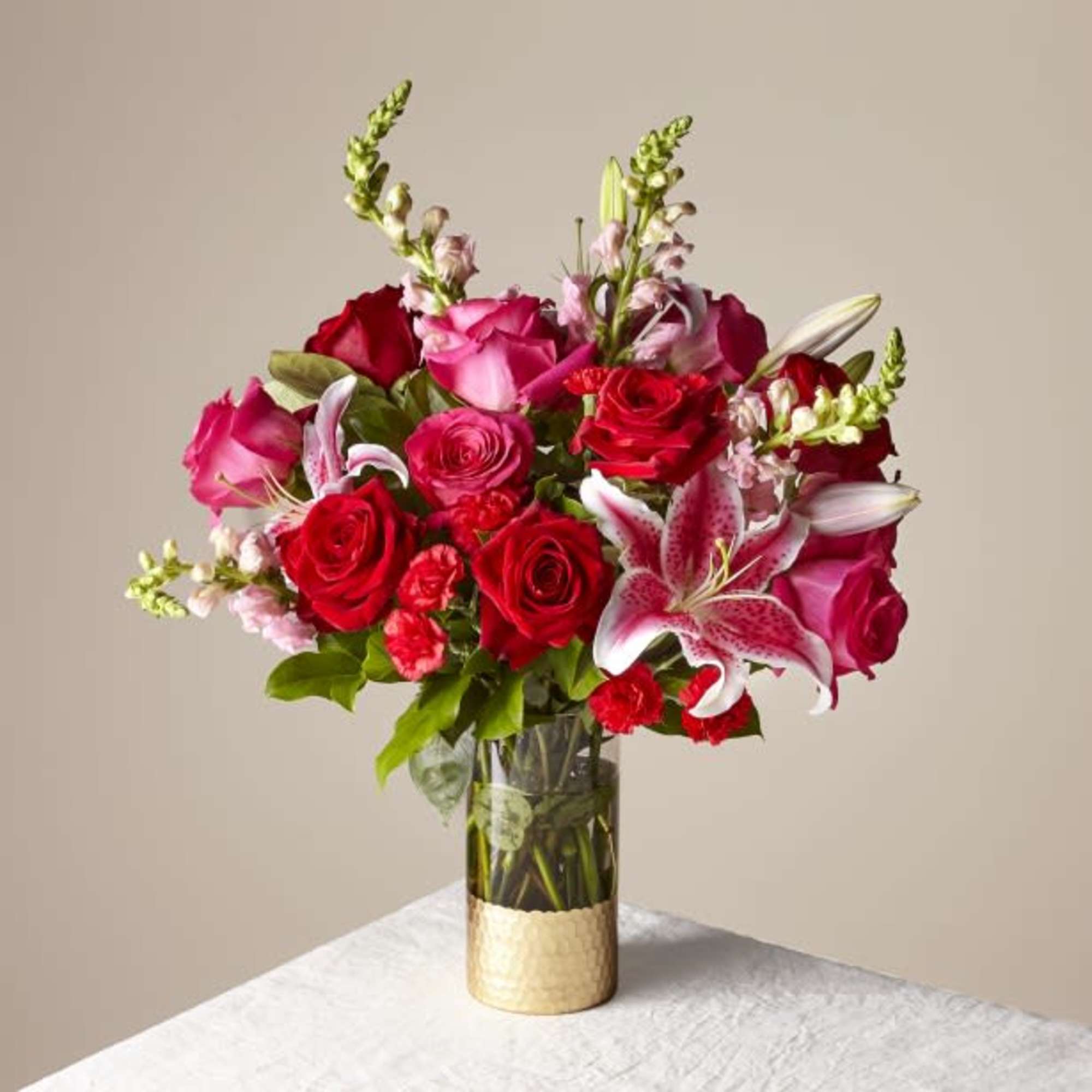 Bouquet of red and pink roses with lilies in a glass vase