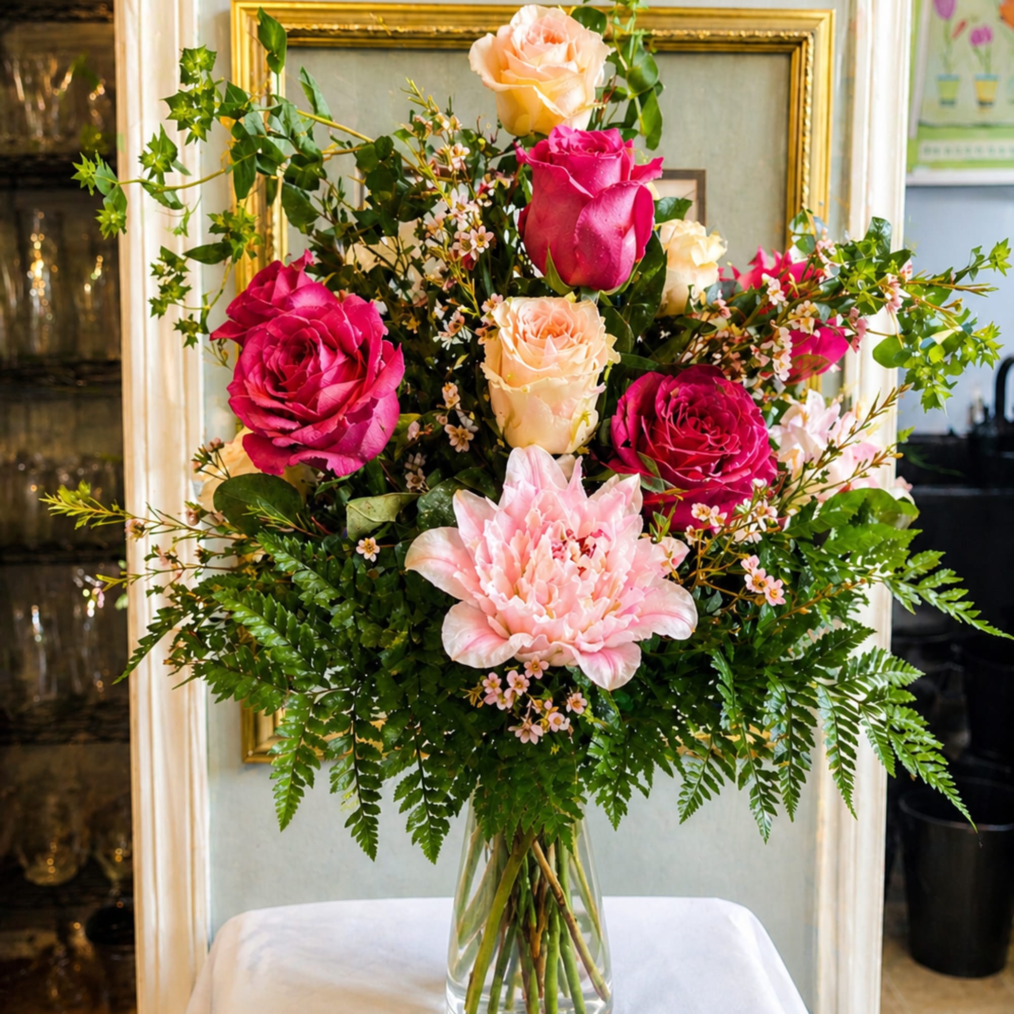 Tall bouquet of pink and peach roses in a clear glass vase