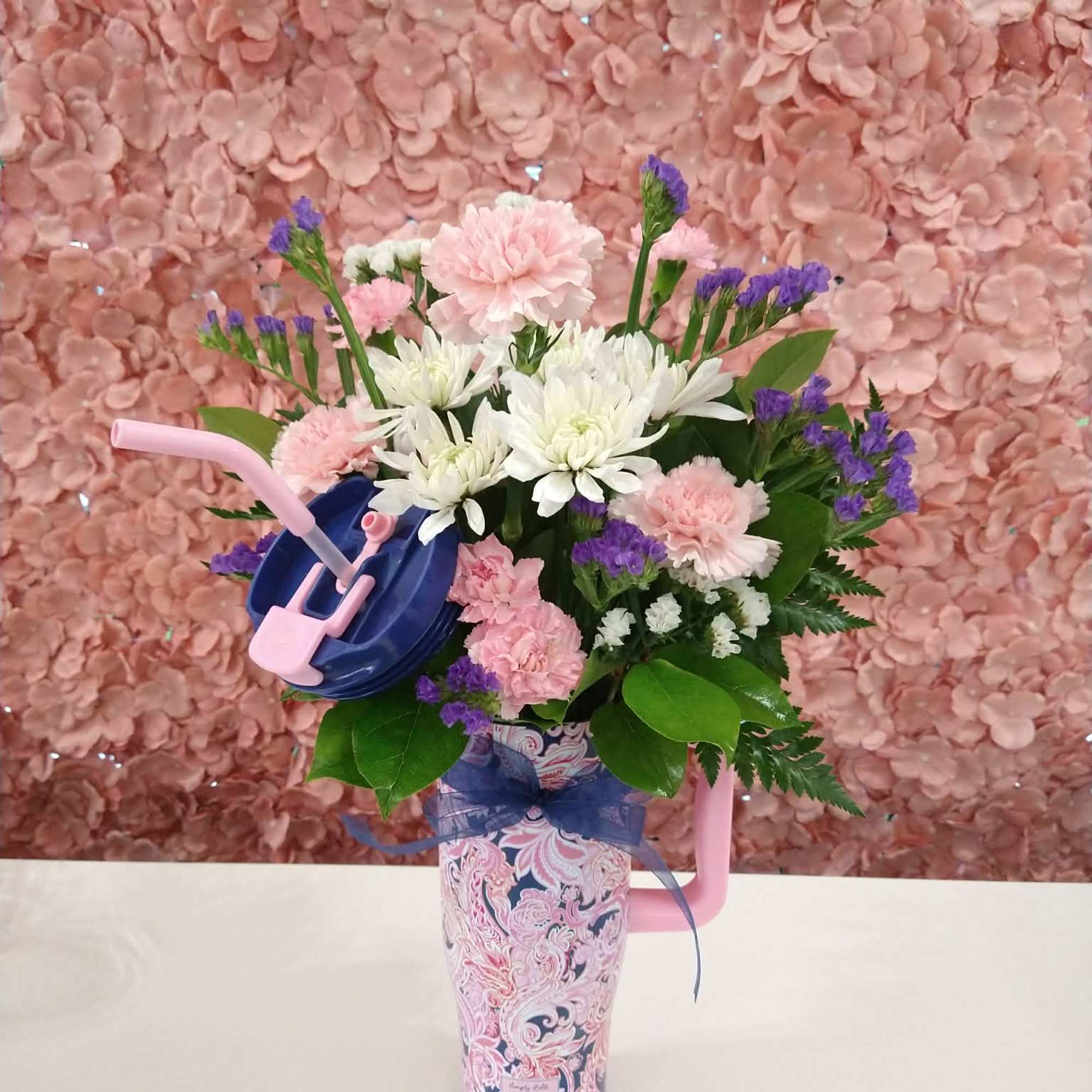 An assortment of florals in a sturdy tumbler with a lid and