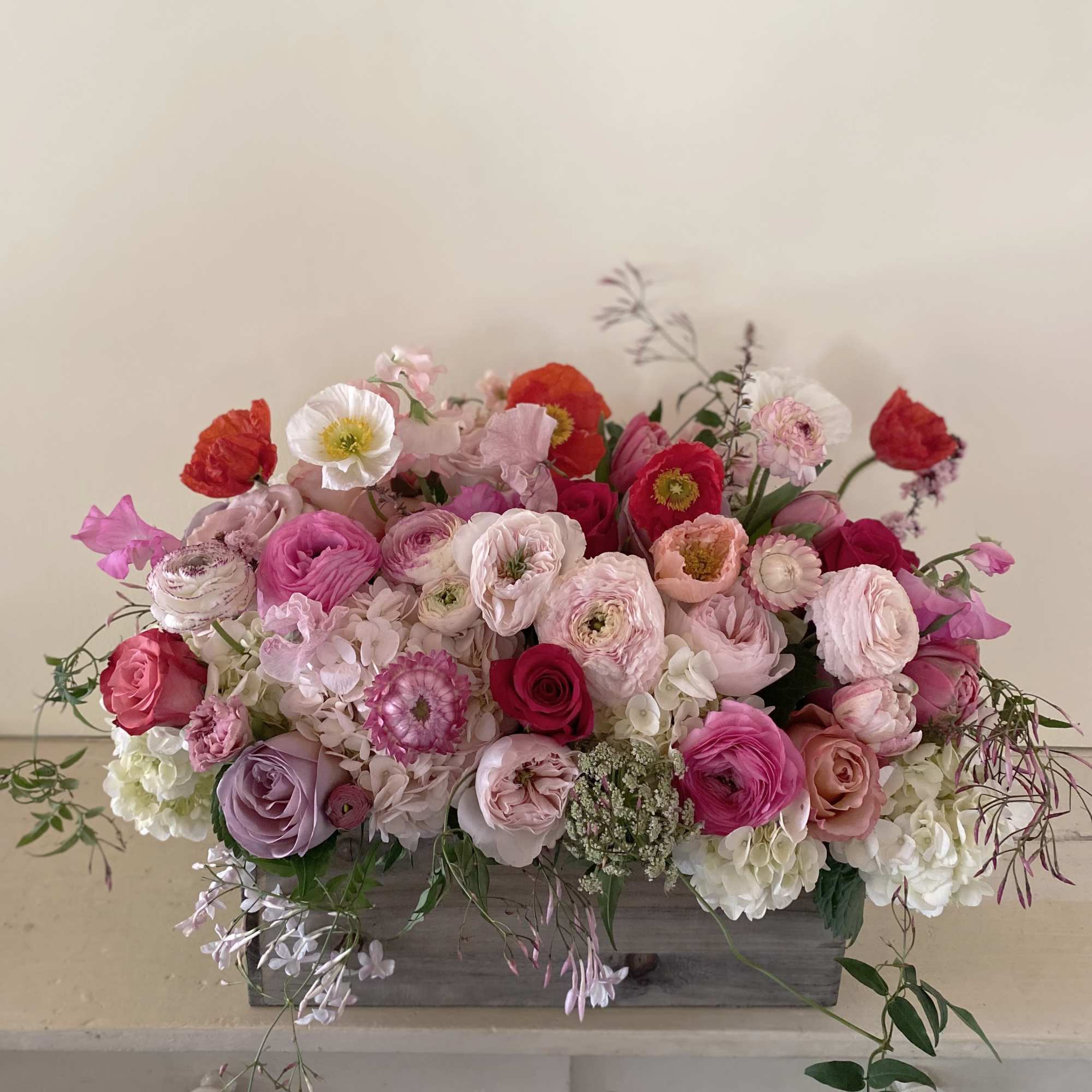Mixed pink and white floral arrangement in a gray wooden box