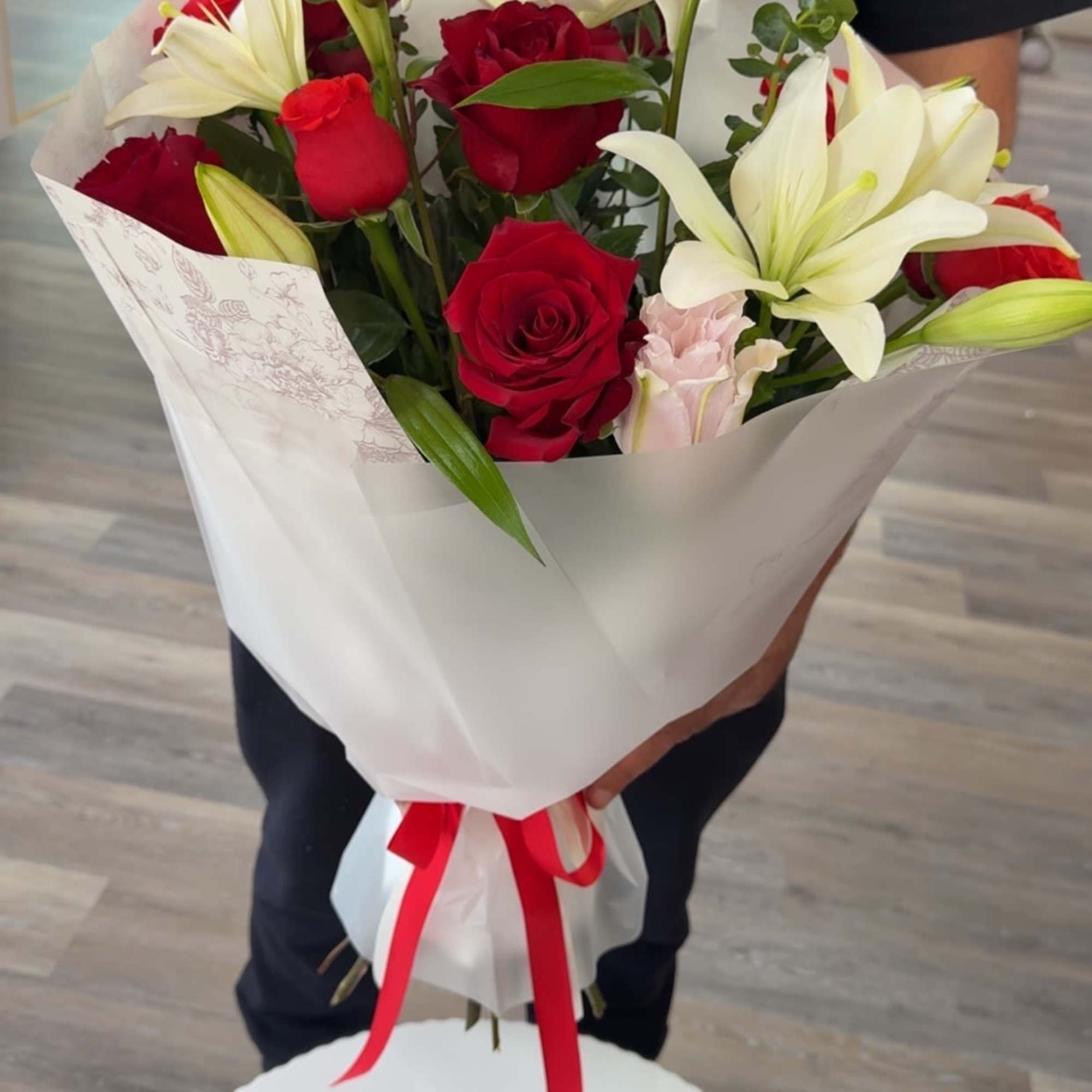 Deep red roses and large white lilies come together in a romantic