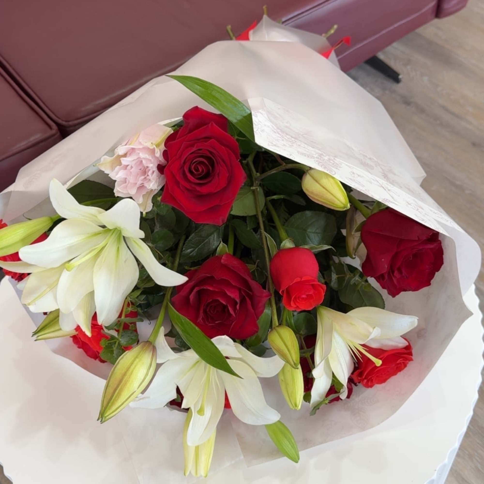 Deep red roses and large white lilies come together in a romantic