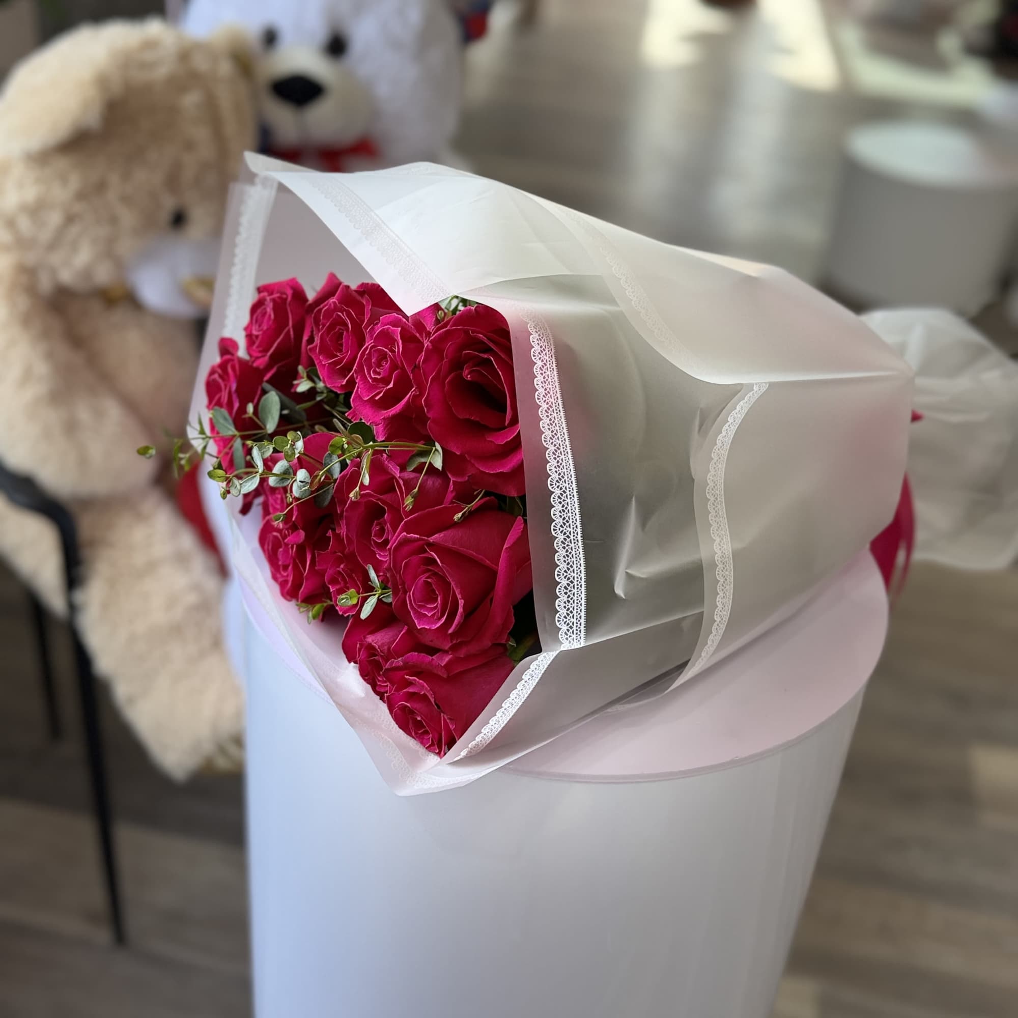 A dense cluster of vivid hot pink roses takes center stage in