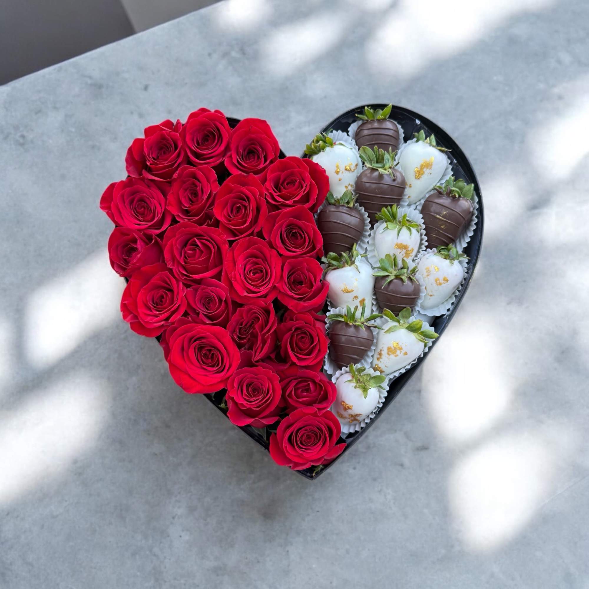 Heart-shaped box with red roses and chocolate-covered strawberries