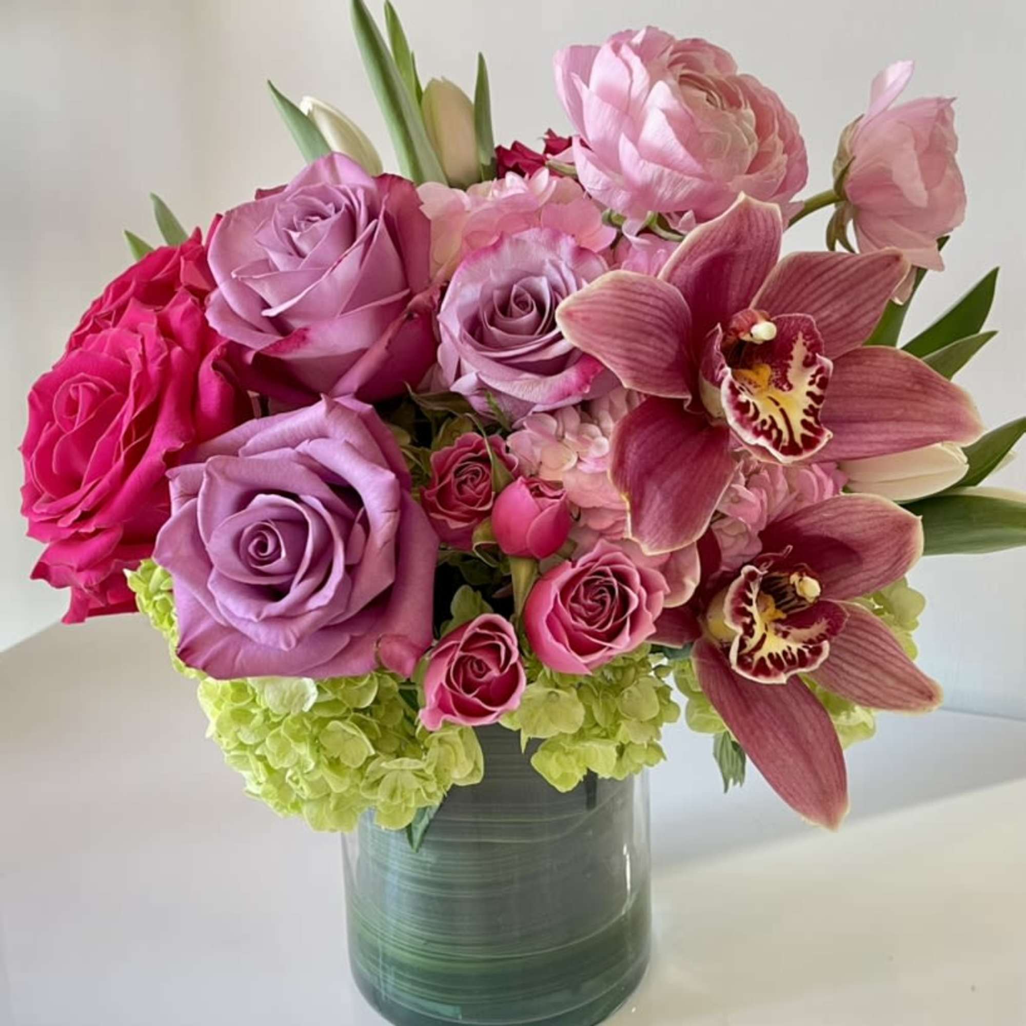 A lush, romantic arrangement overflowing with soft pinks and vibrant fuchsia tones.