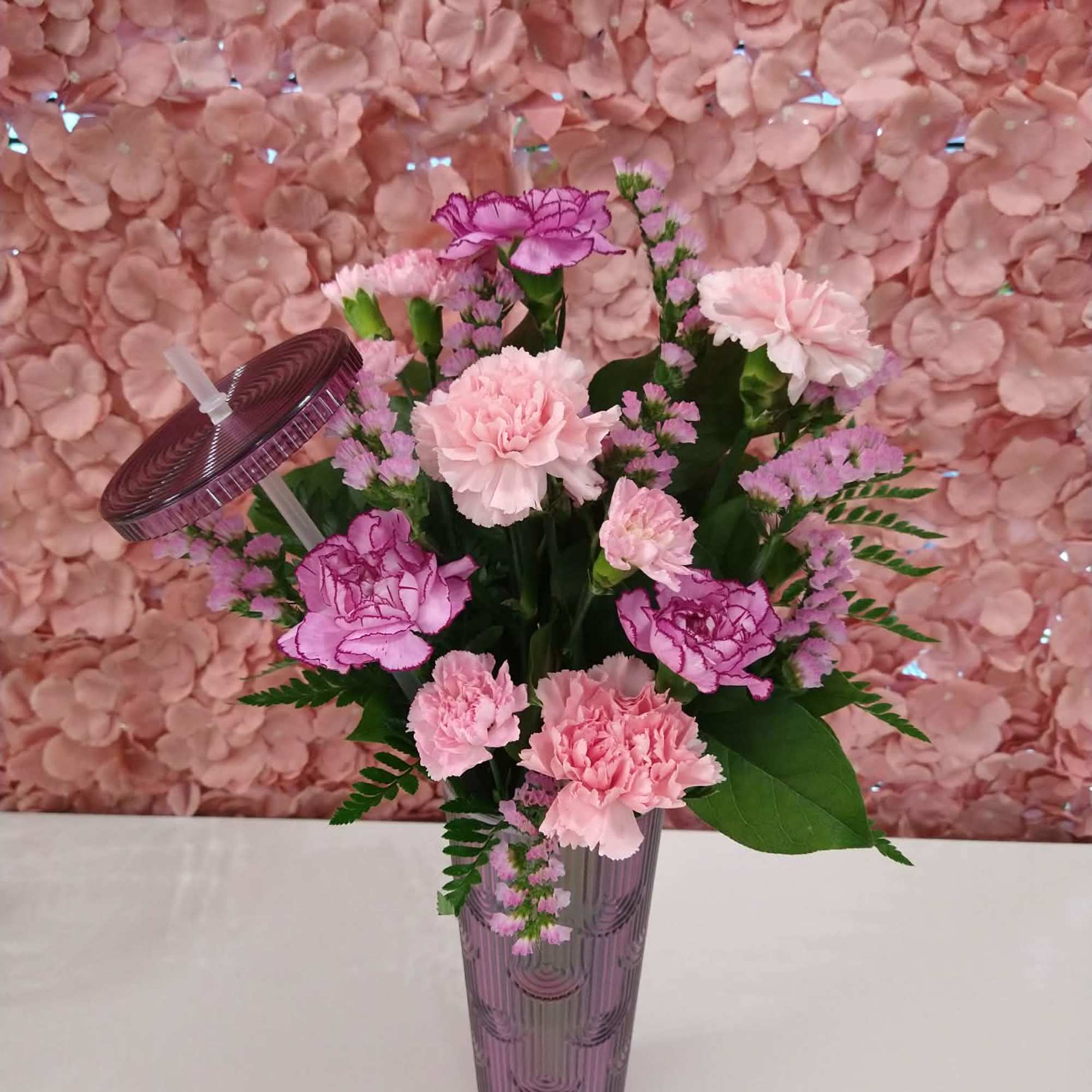 An assortment of florals in a sturdy tumbler with a lid and