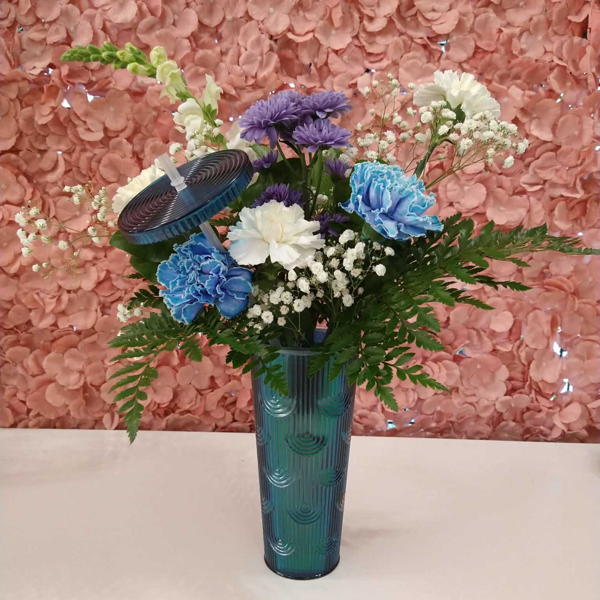 An assortment of florals in a sturdy tumbler with a lid and