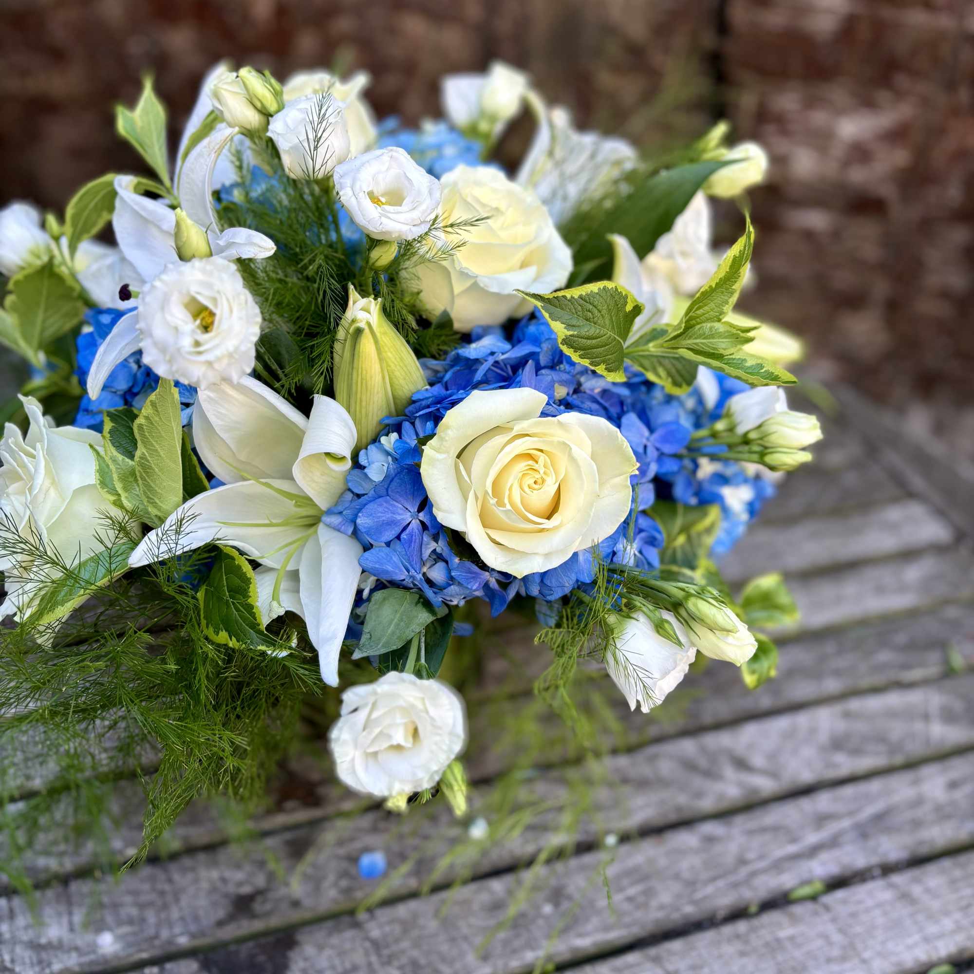 Bouquet of white and blue flowers with green foliage
