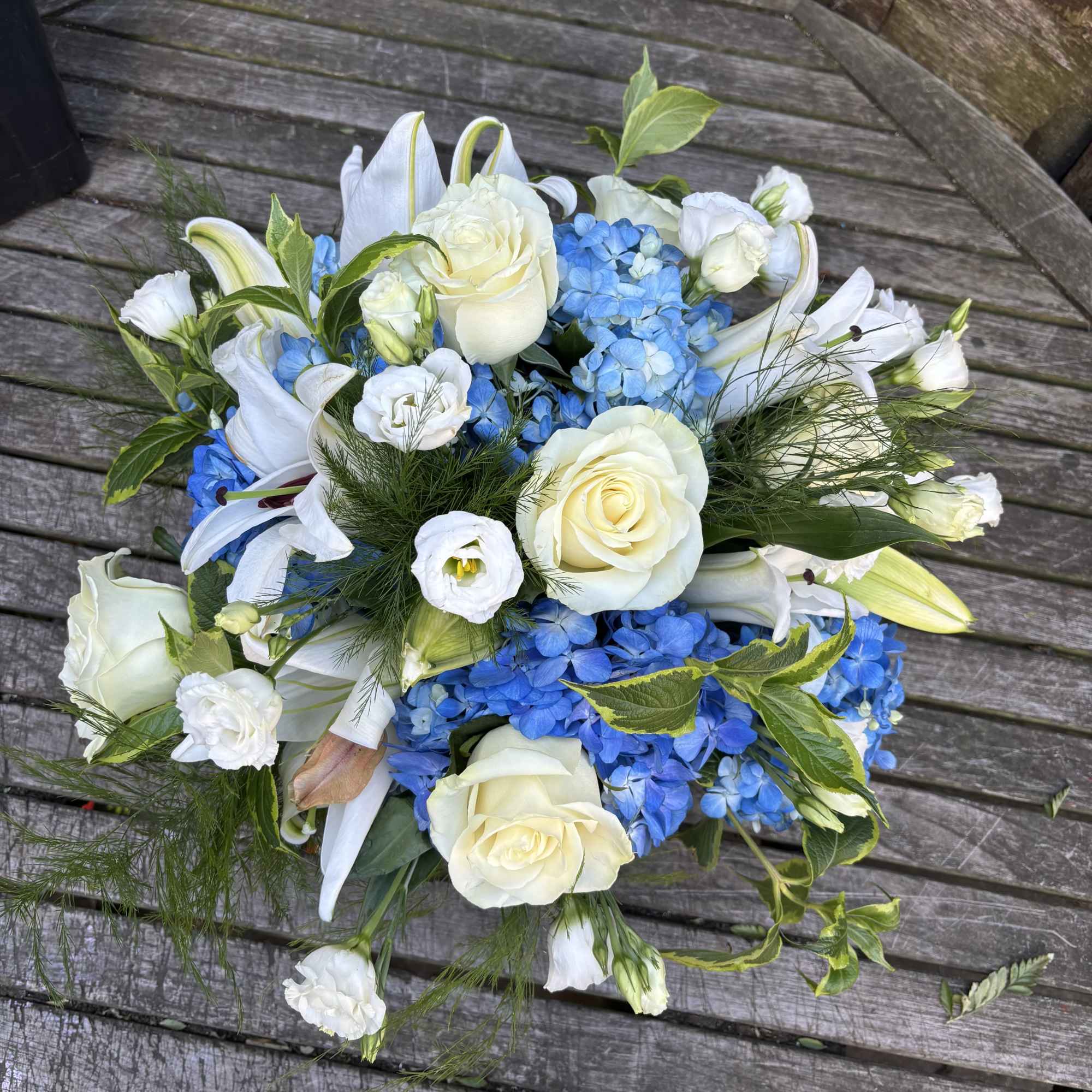 Bouquet of white roses, blue hydrangeas, and white lilies