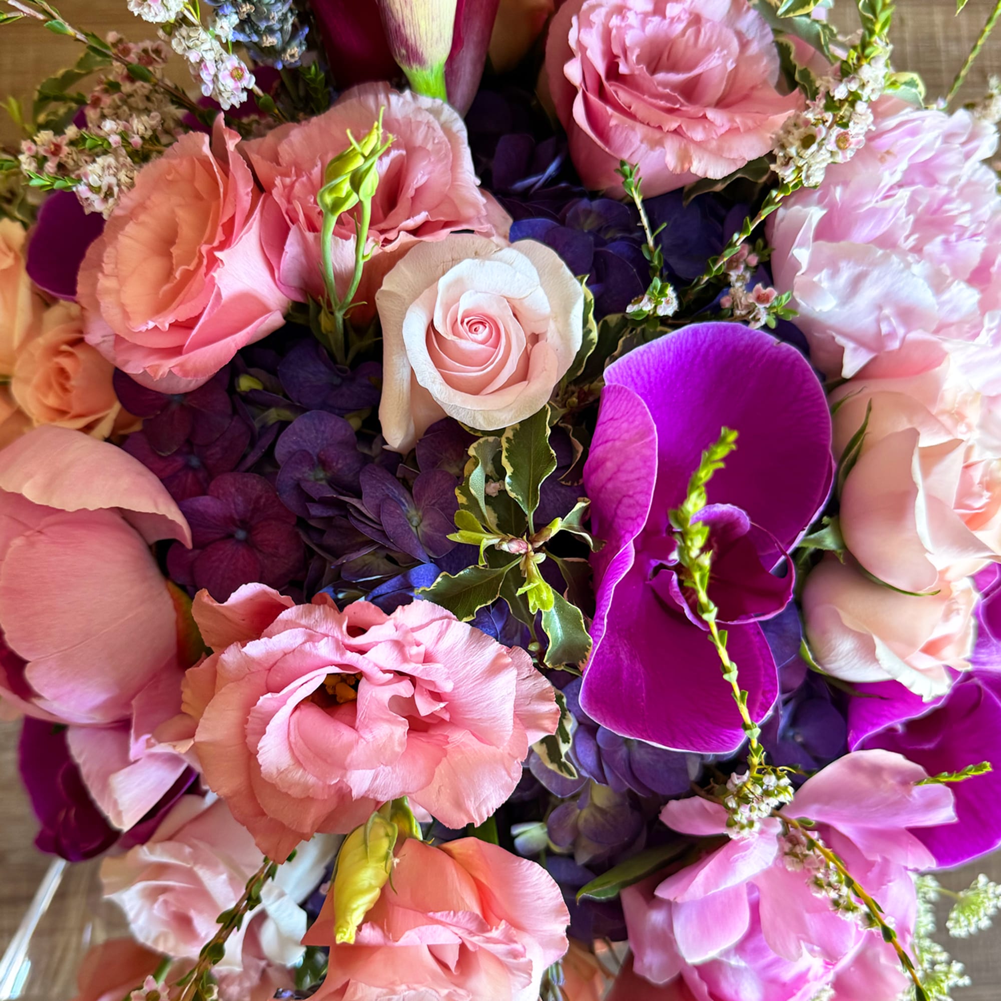 Pink and purple bouquet with roses, orchids, and hydrangeas