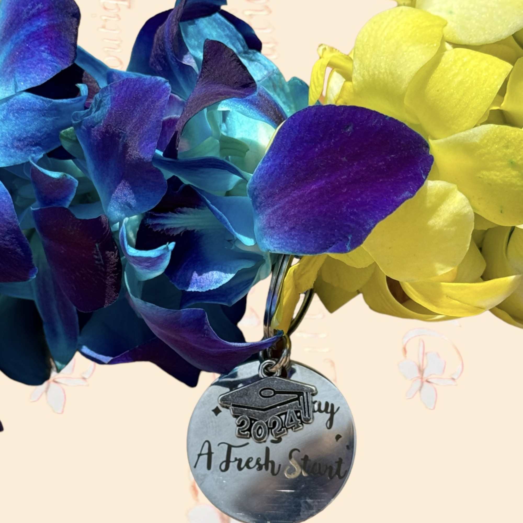 Blue and yellow orchid blooms with a graduation charm