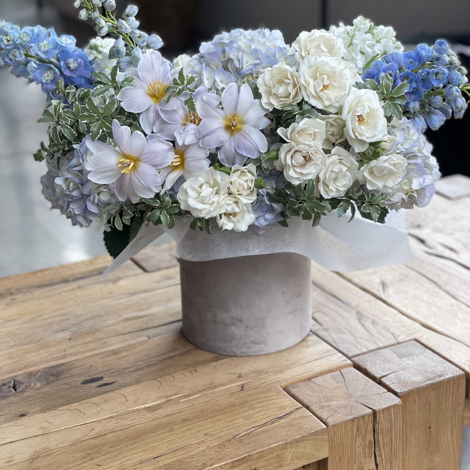 Blue and white floral arrangement in a gray vase