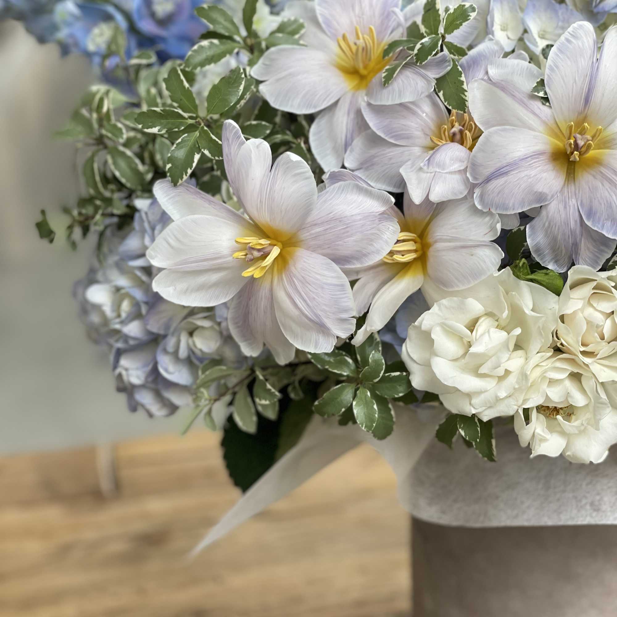Bouquet of pale blue and white flowers with green variegated foliage