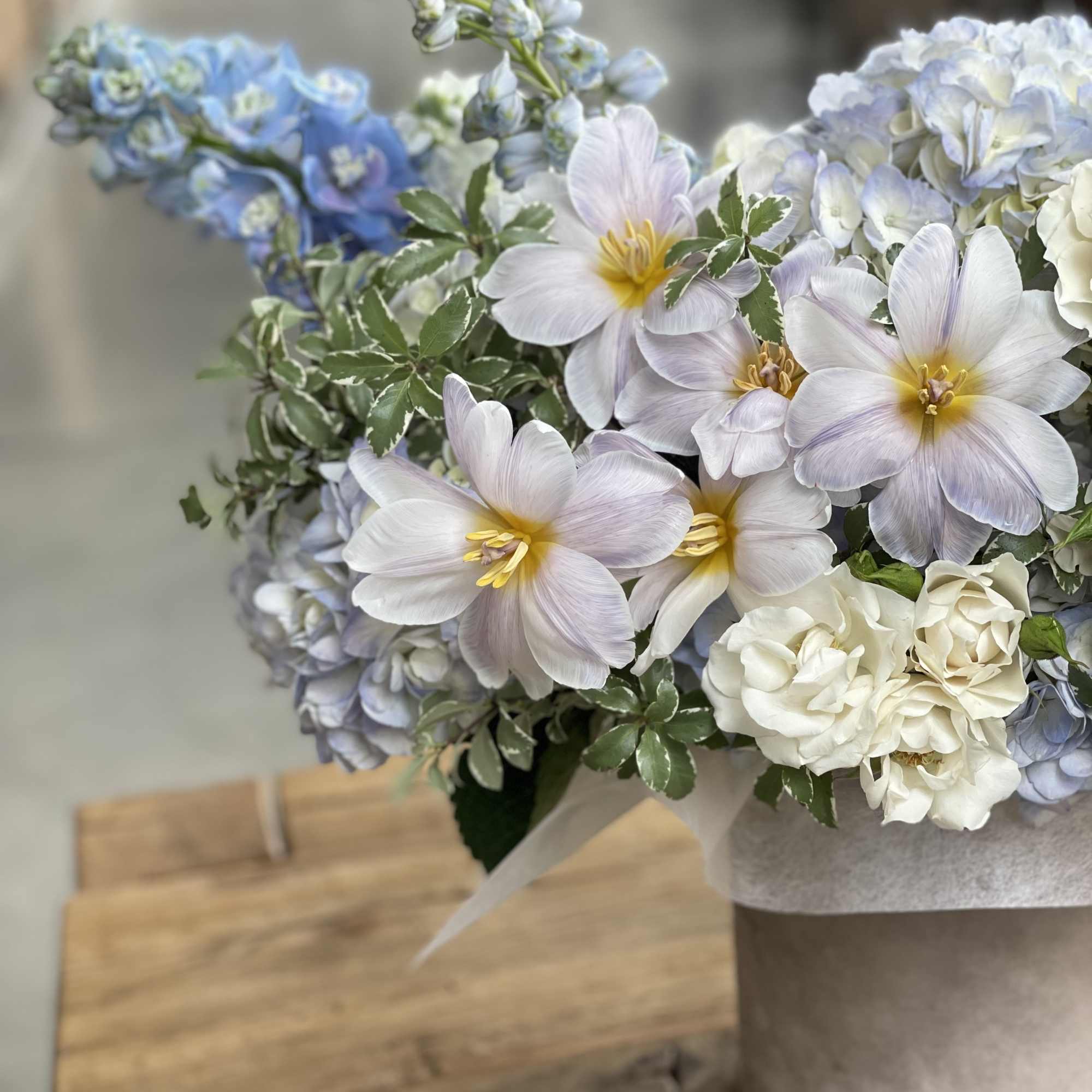 Bouquet of pale blue and white flowers in a wrapped container