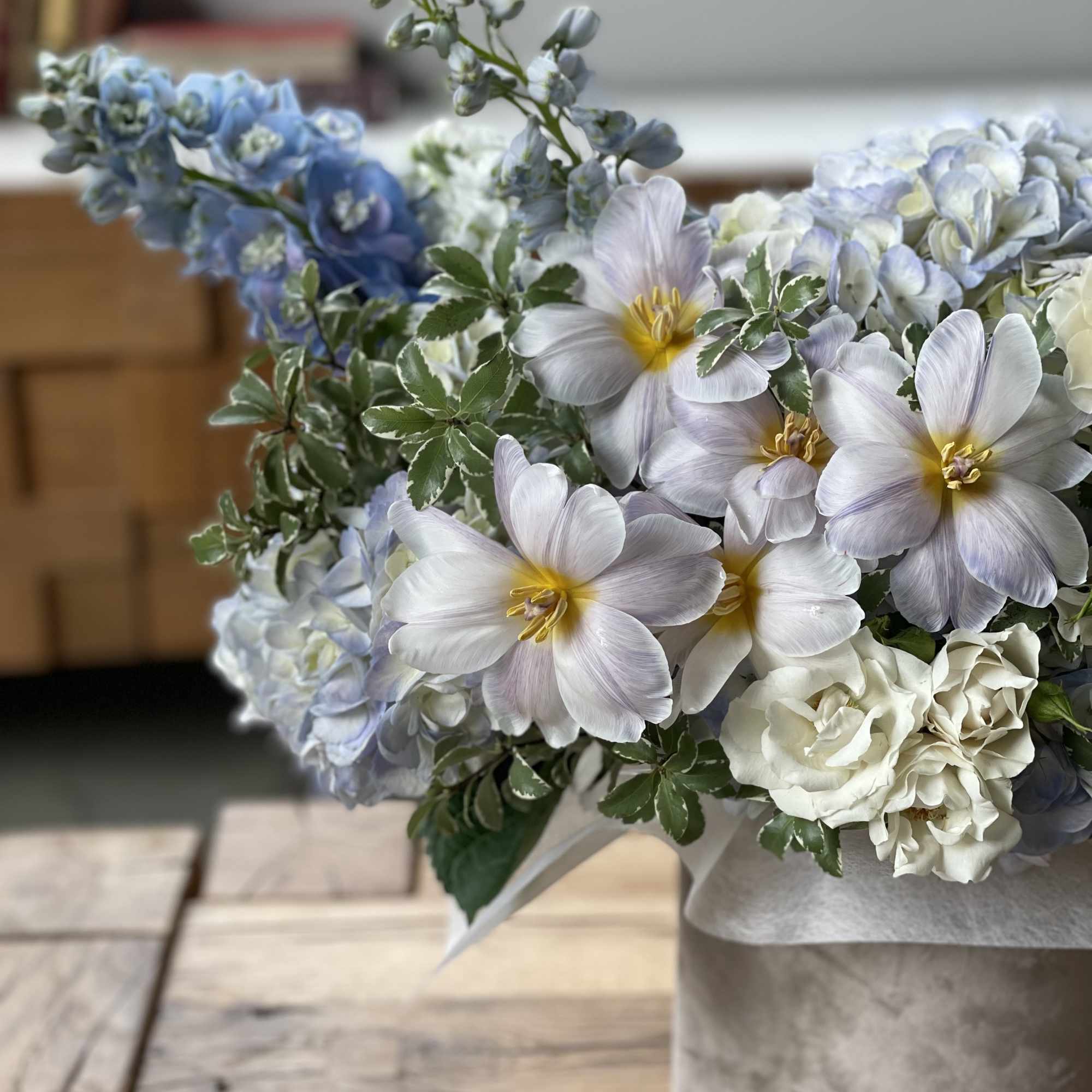 Bouquet of pale blue and white flowers in a gray vase