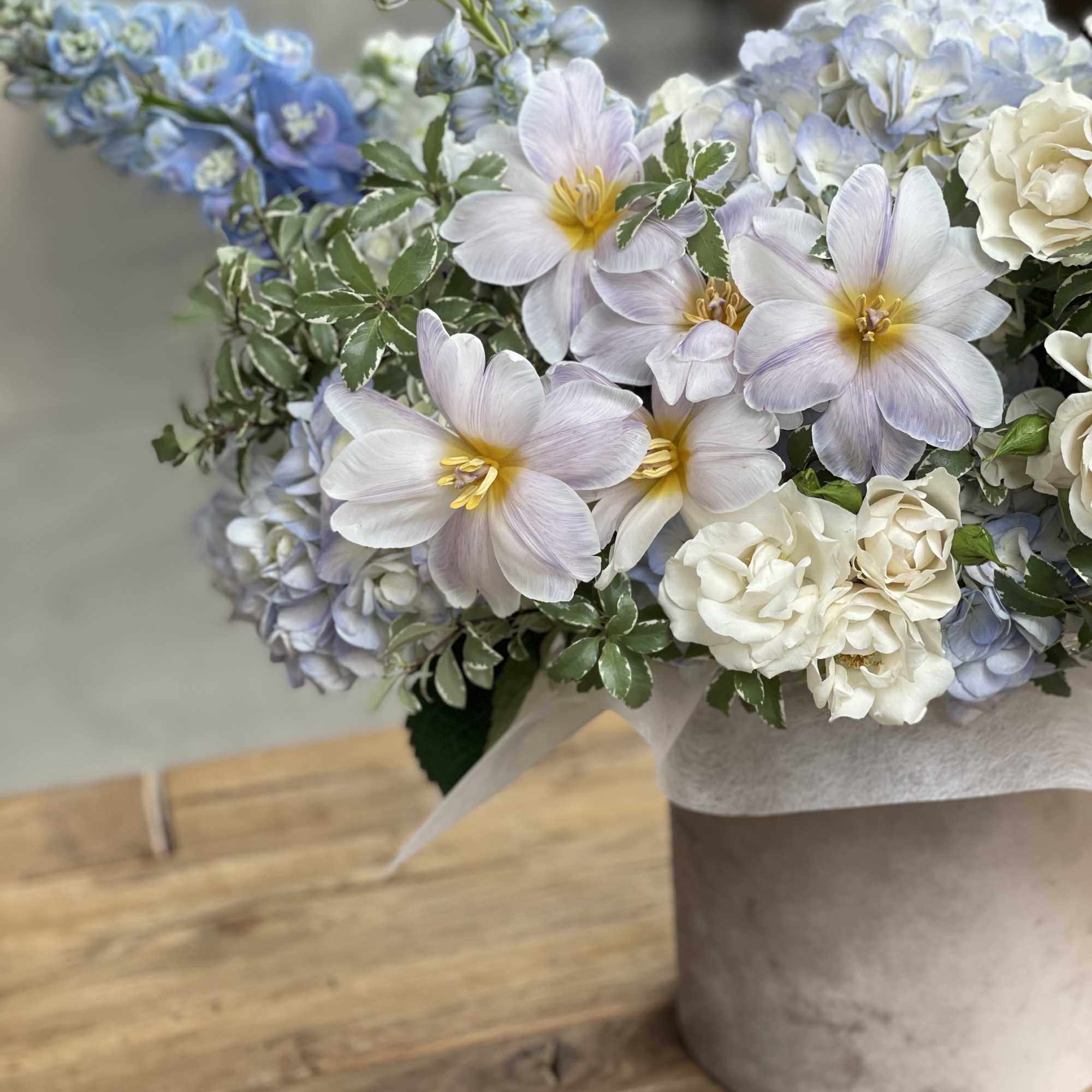 Bouquet of pale blue and white flowers in a gray vase