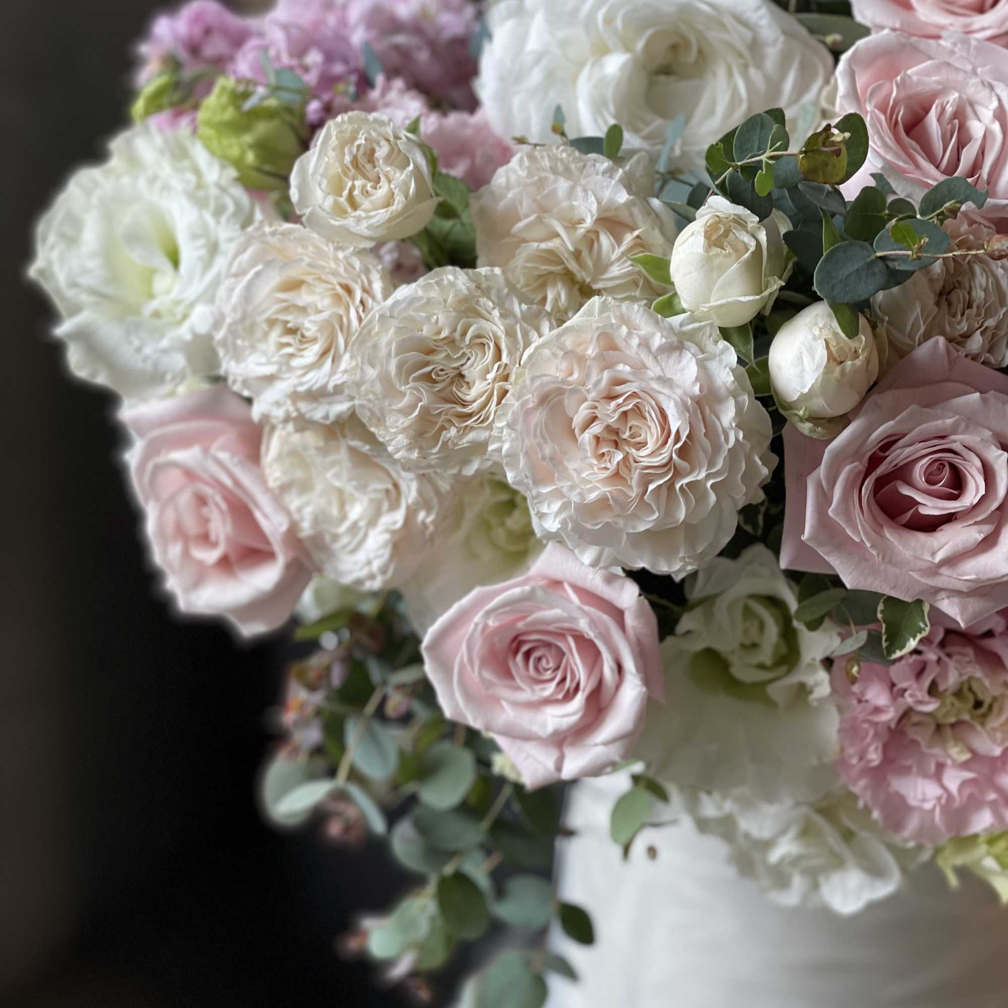Bouquet of pink and white roses with eucalyptus in a white wrap