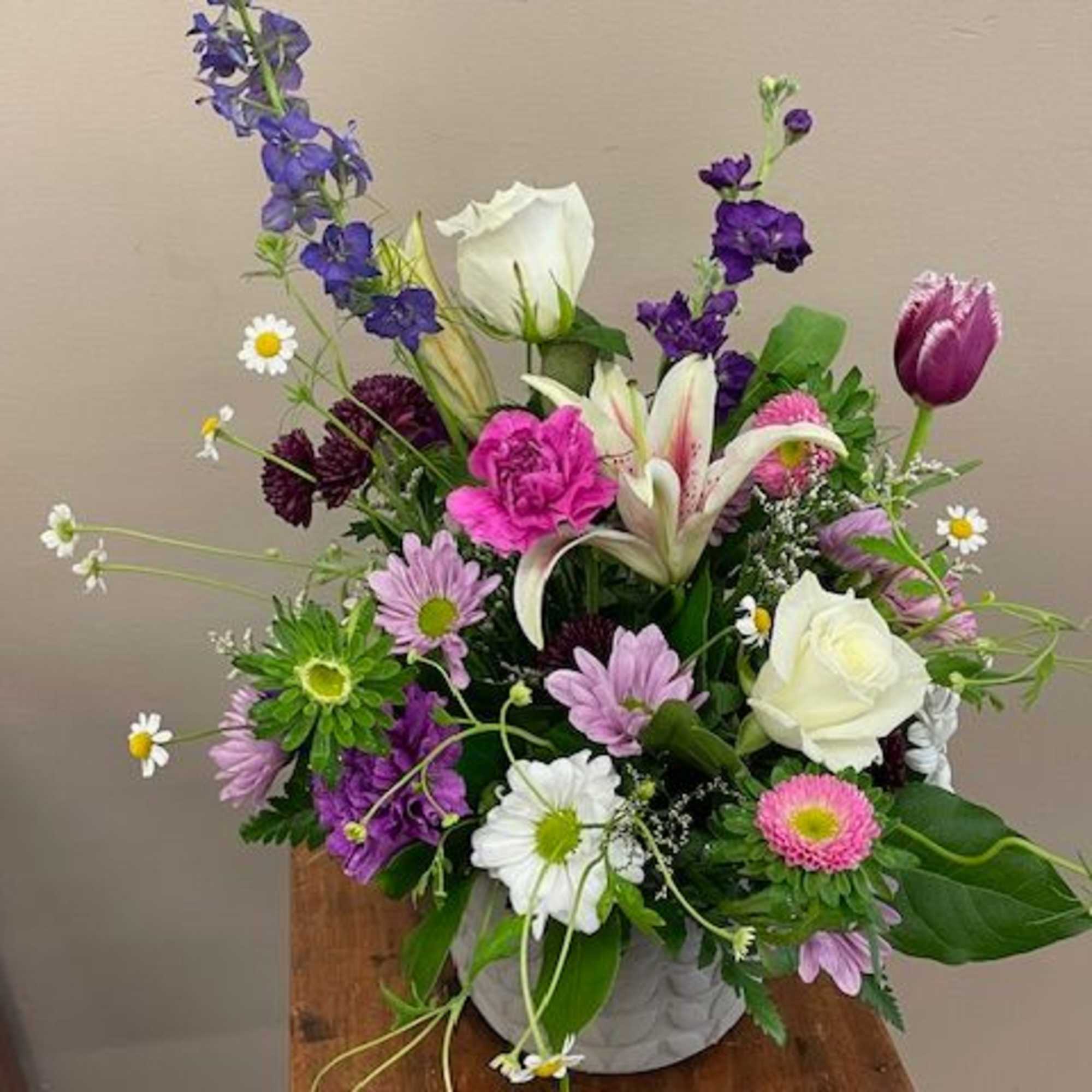 Mixed bouquet in a white vase with purple, pink, and white flowers