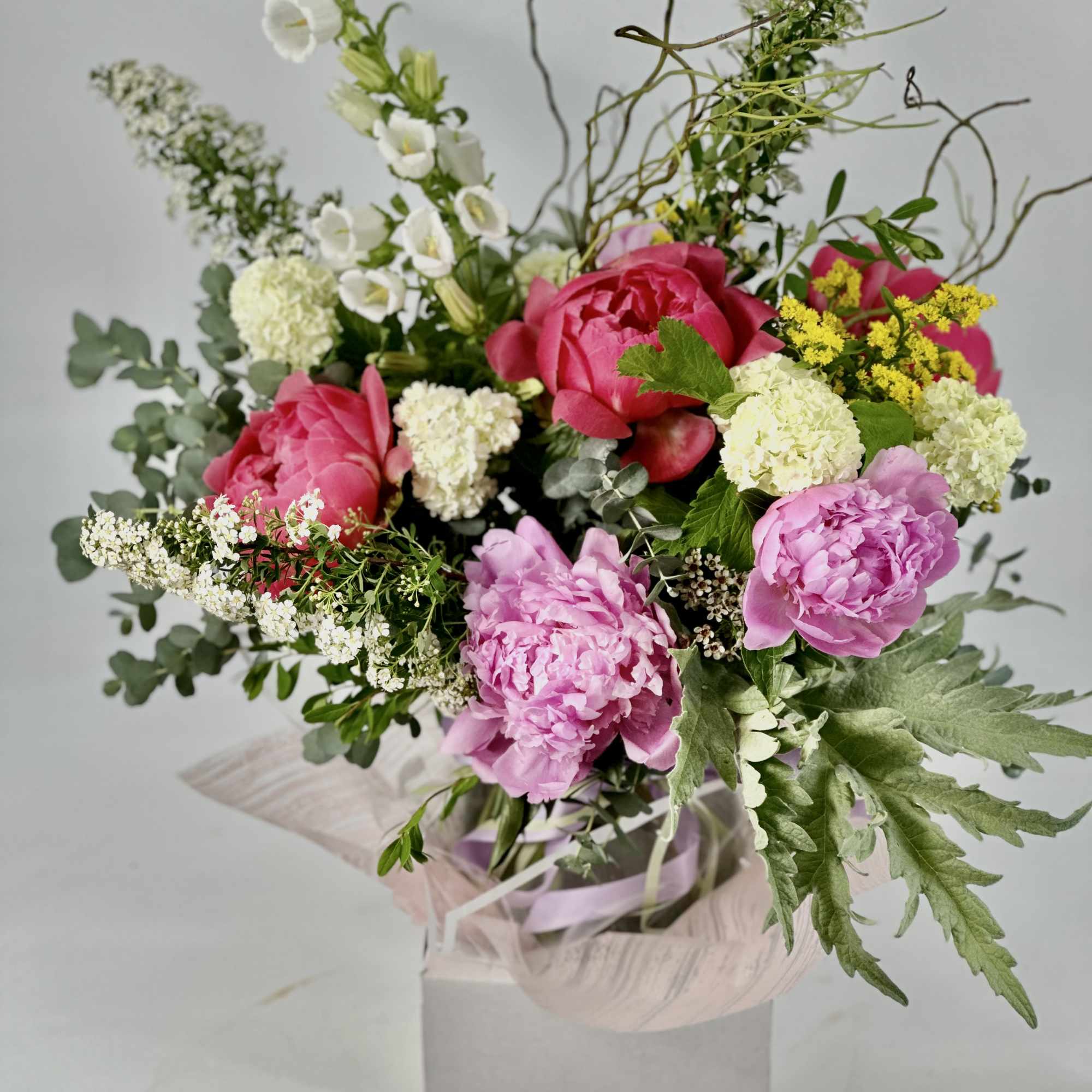 Pink peonies and white flowers in a wrapped gift box arrangement
