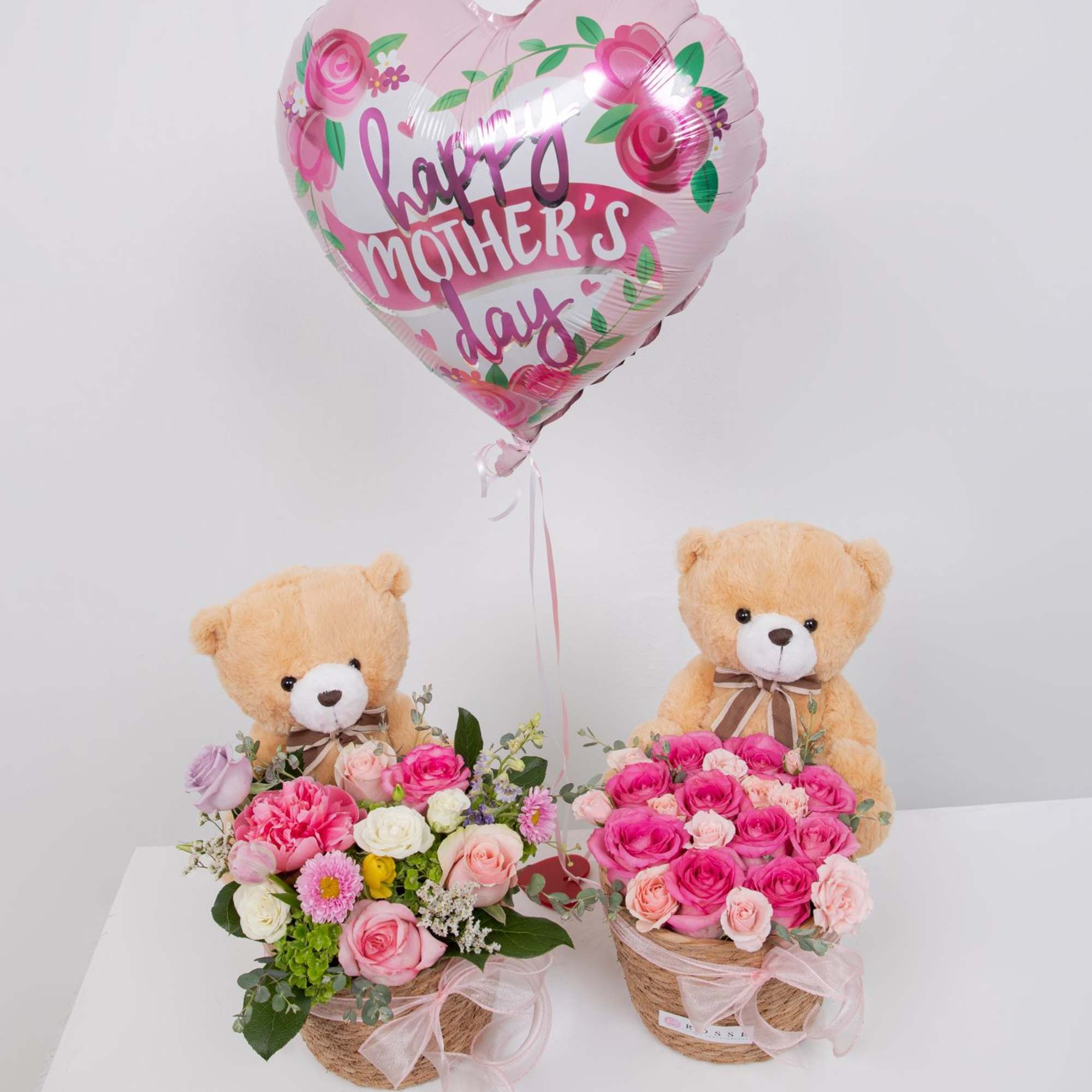 A soft mix of pink and white blooms with a cuddly teddy