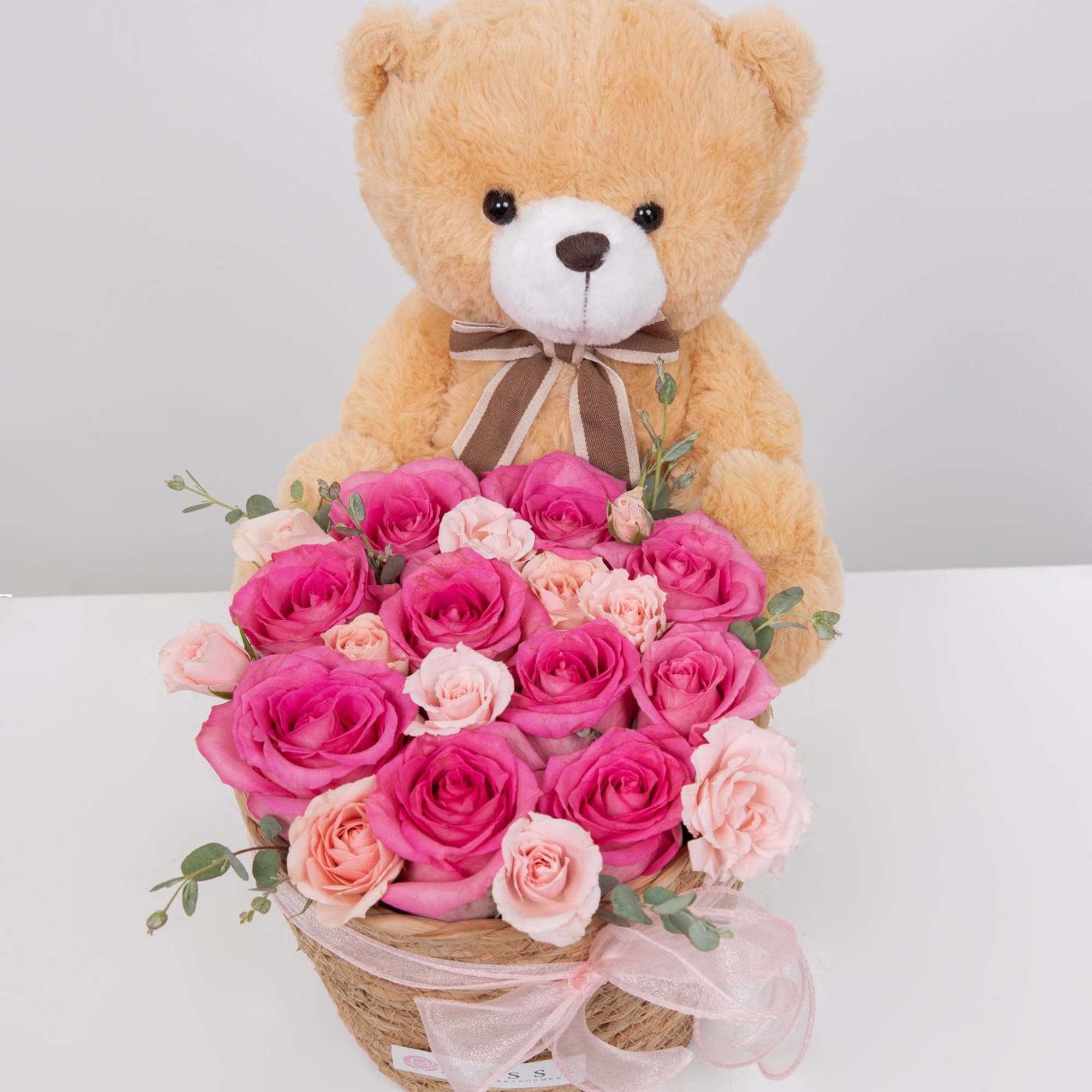 A sweet mix of pink roses and a cute teddy bear, all