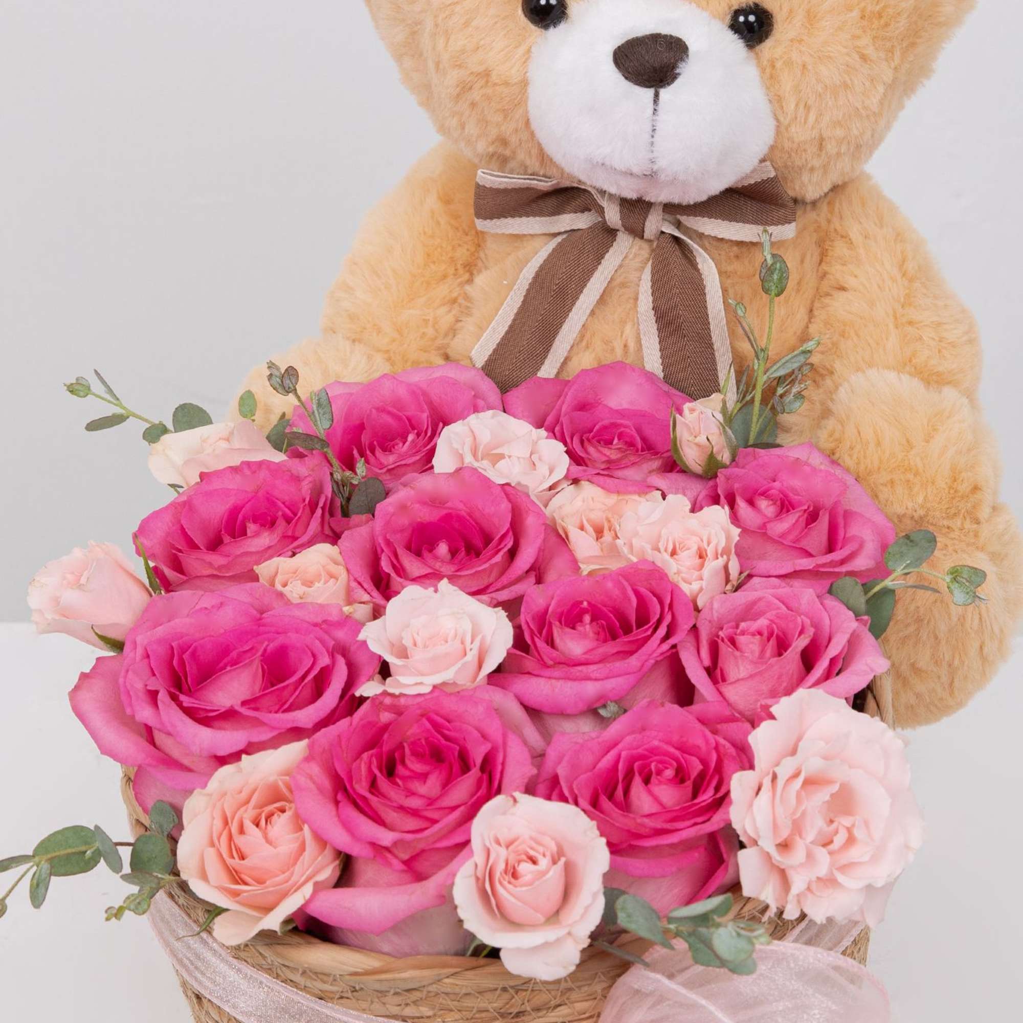 A sweet mix of pink roses and a cute teddy bear, all