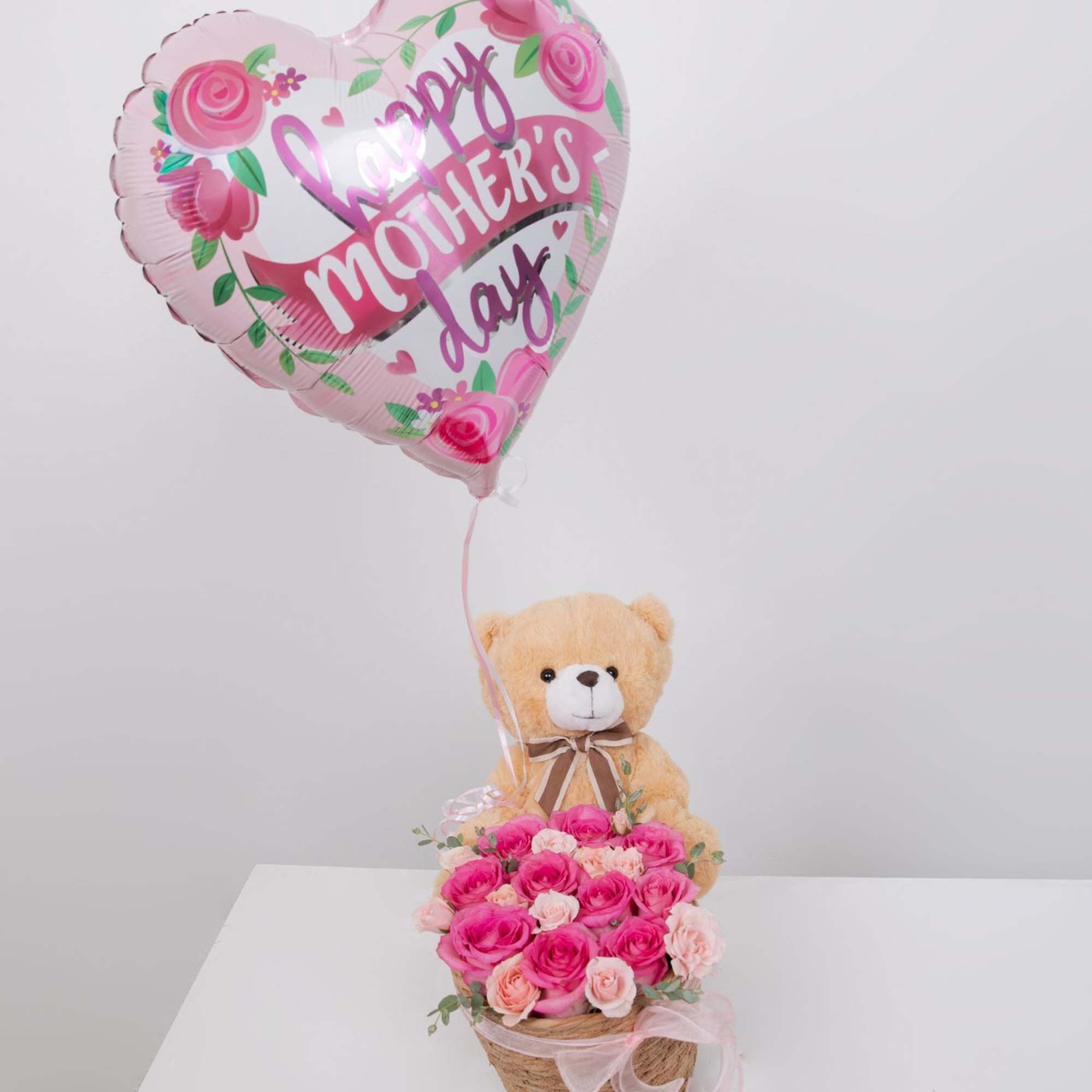 A sweet mix of pink roses and a cute teddy bear, all