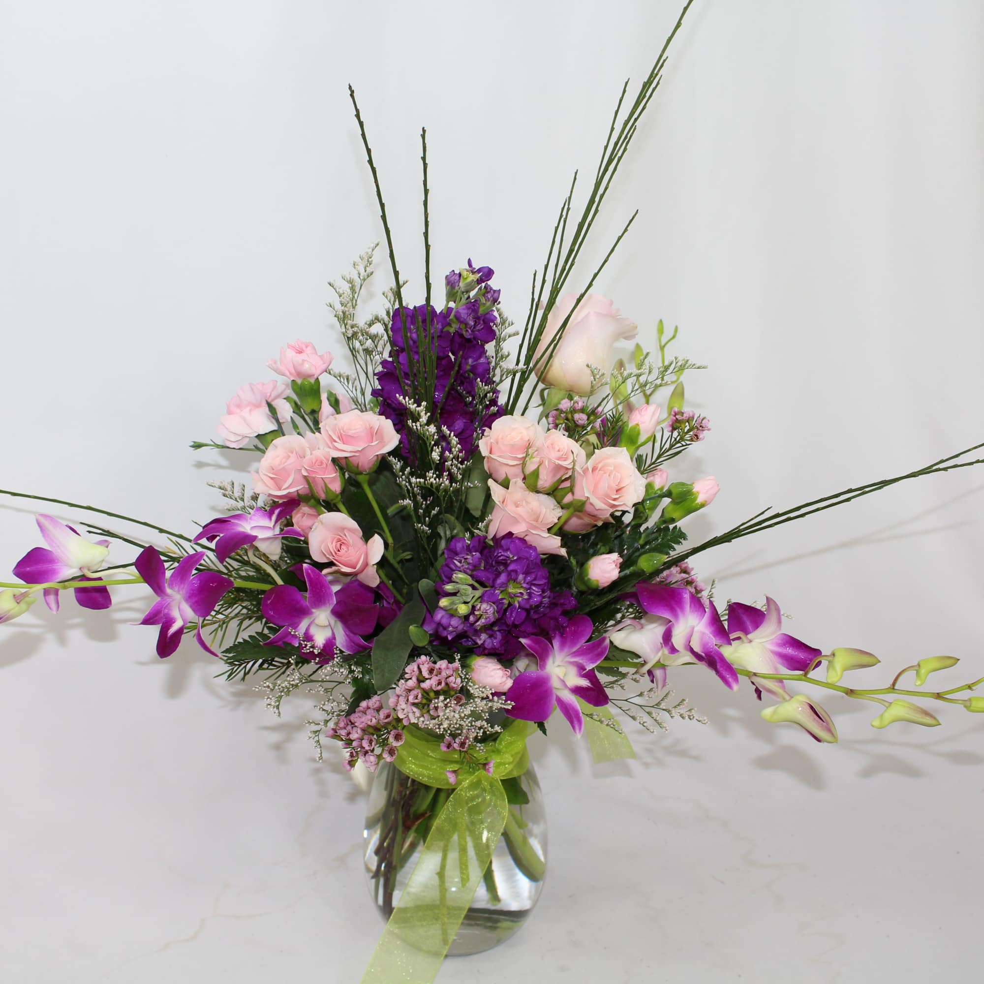 Purple and pink floral arrangement in a clear glass vase