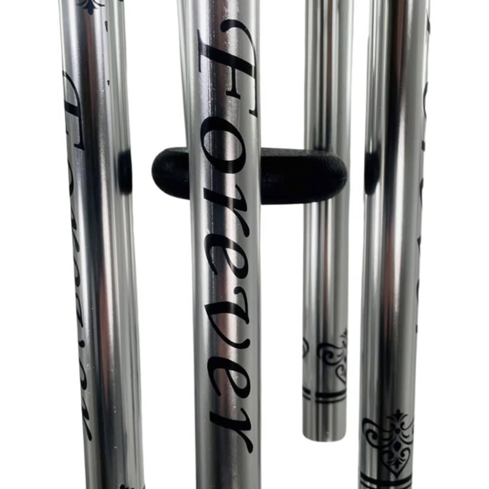 Four silver wind chimes with black decorative patterns and the word "Forever"