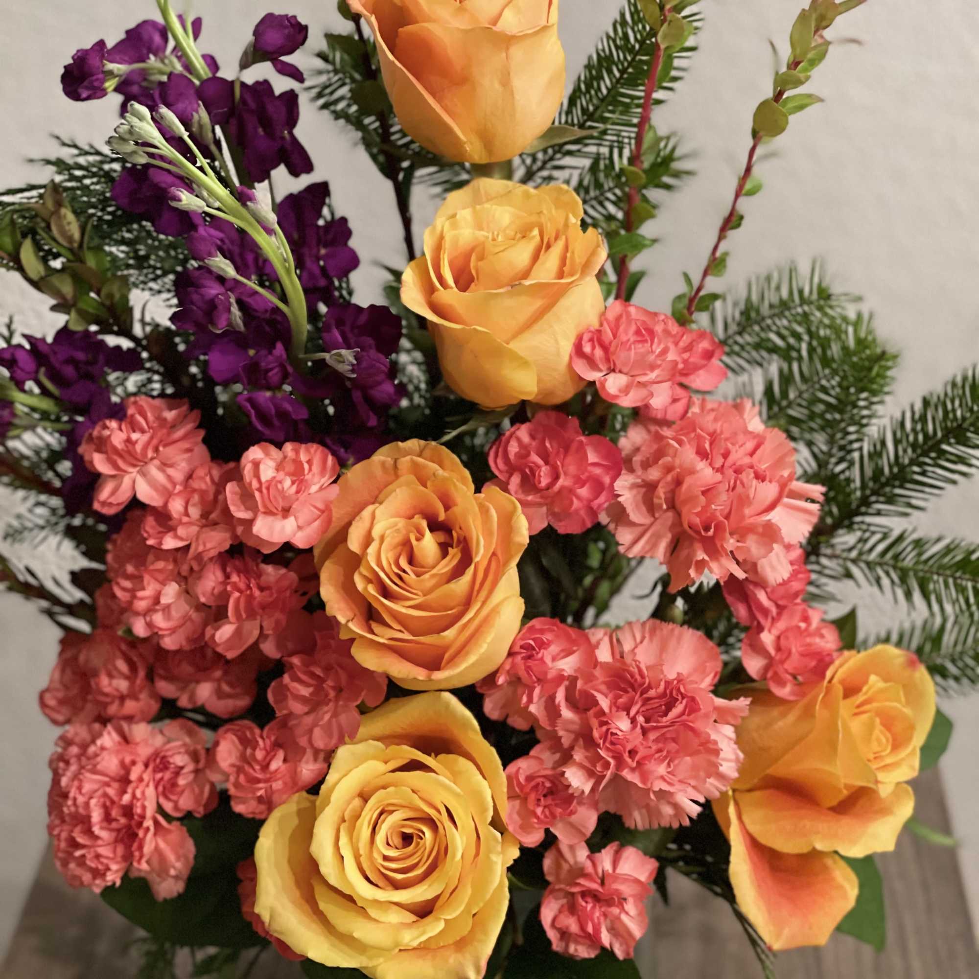 Orange roses and pink carnations in a low floral arrangement