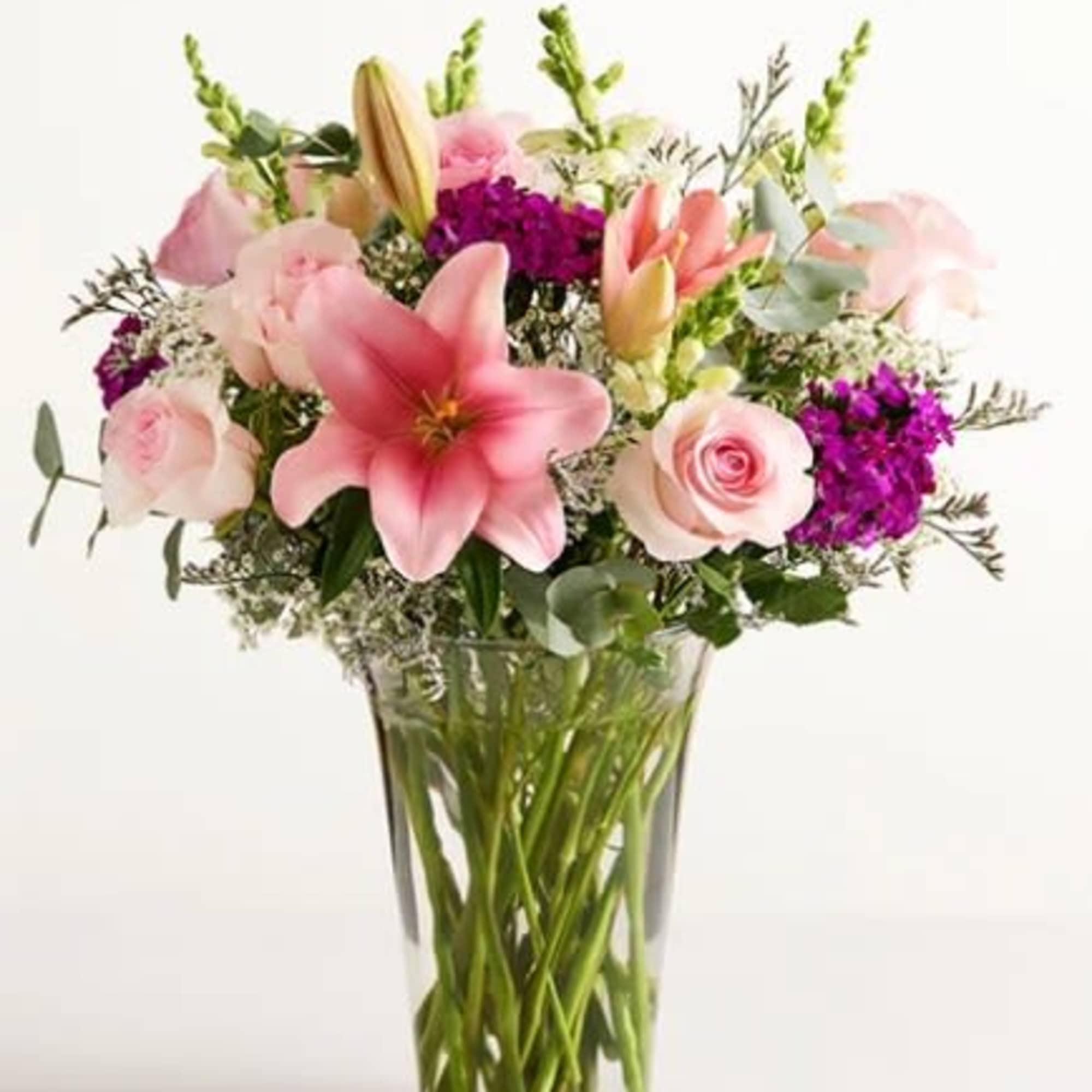 Pink lilies and pale roses with vivid purple accents, snapdragon spikes and