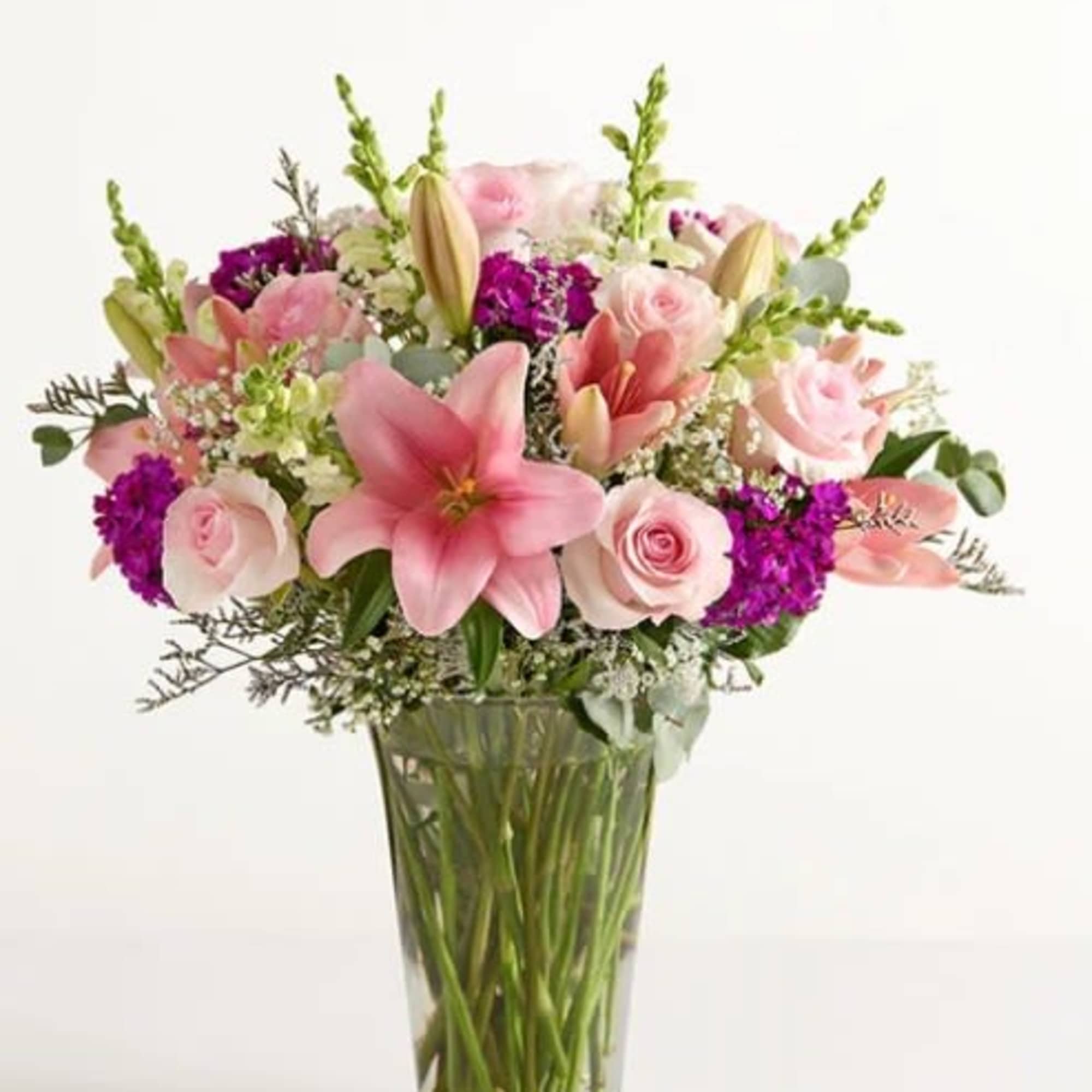 Pink lilies and pale roses with vivid purple accents, snapdragon spikes and