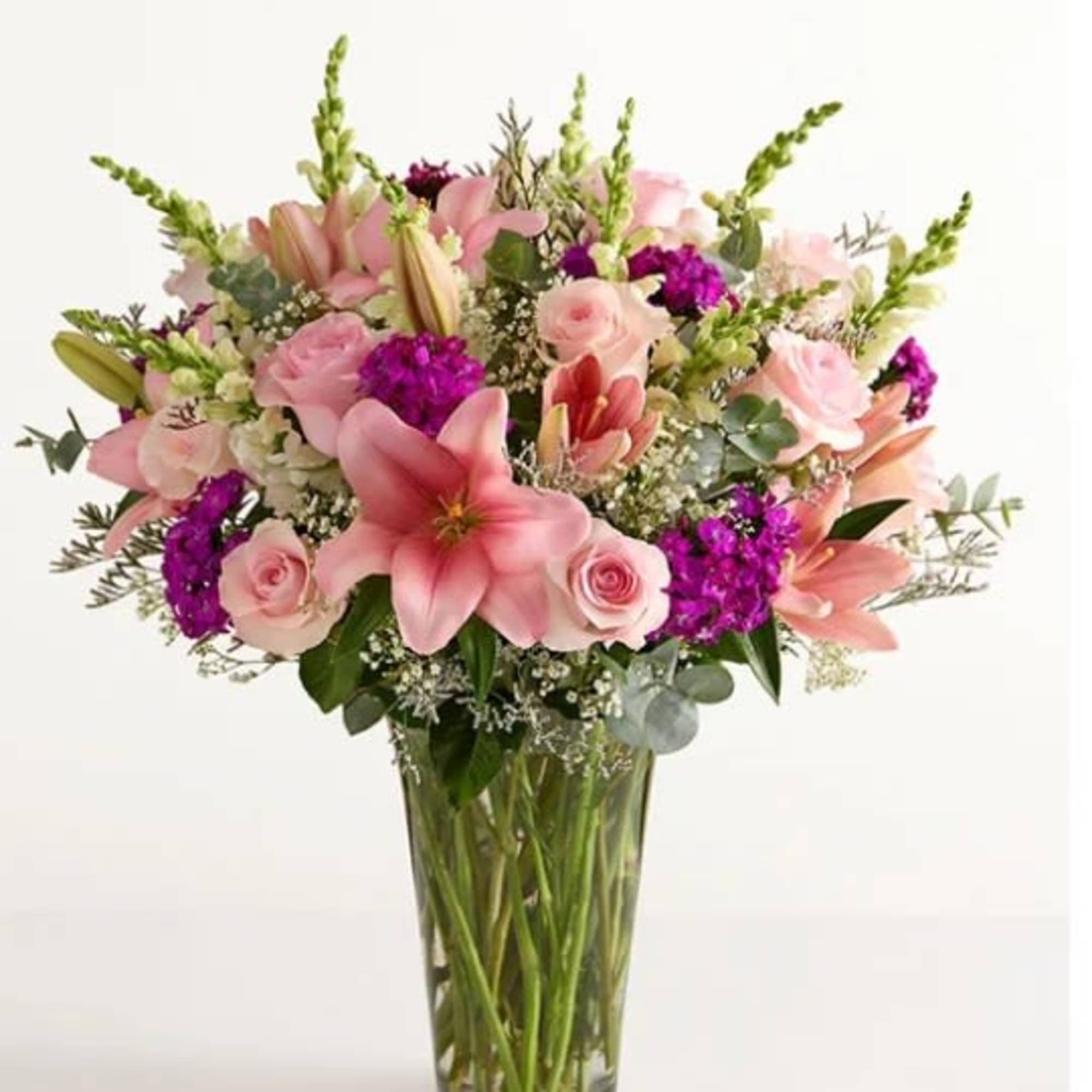 Pink lilies and pale roses with vivid purple accents, snapdragon spikes and